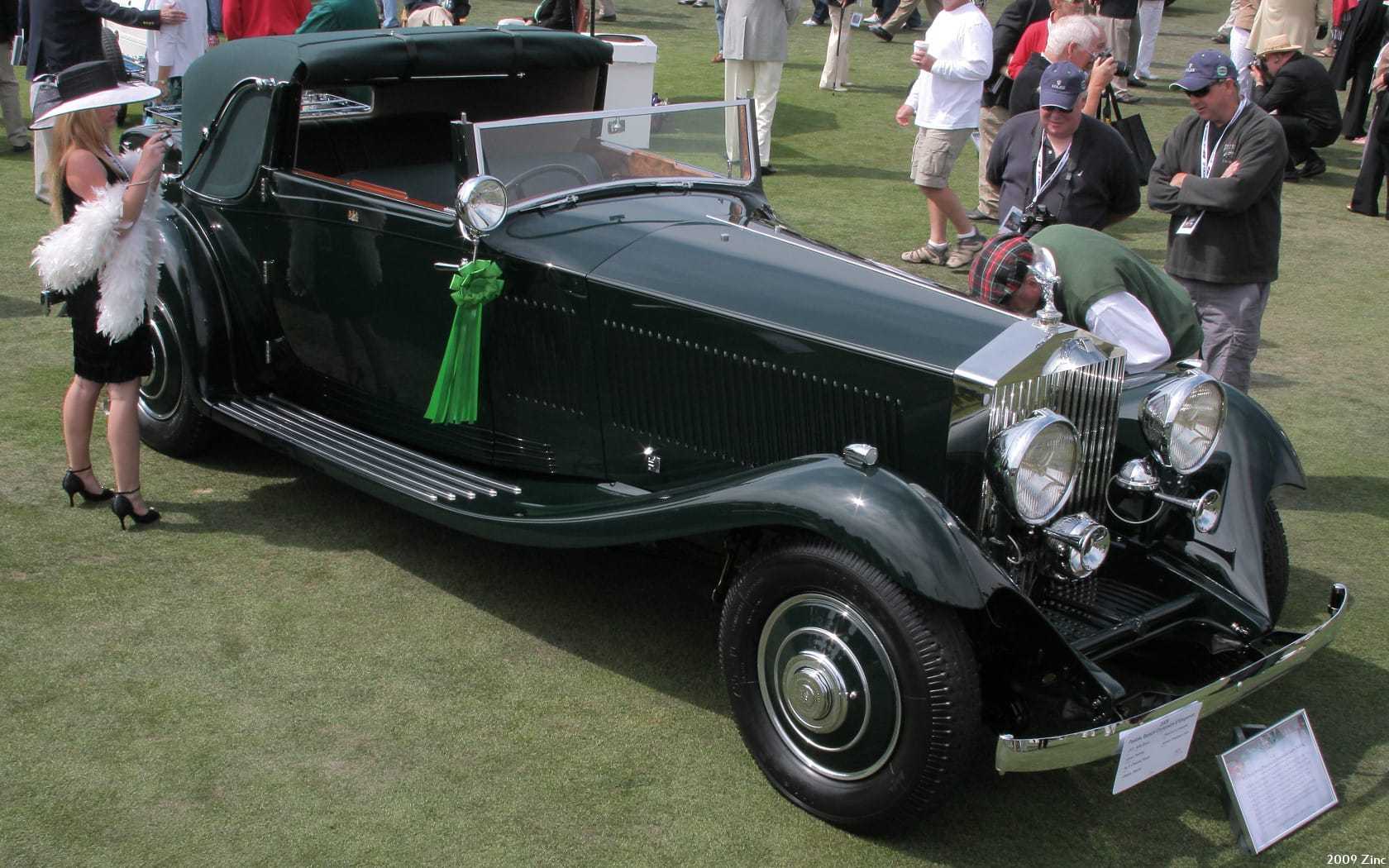 A dark green 1933 Rolls-Royce Phantom II Continental with Gurney Nutting sedanca drophead coachwork at a concours