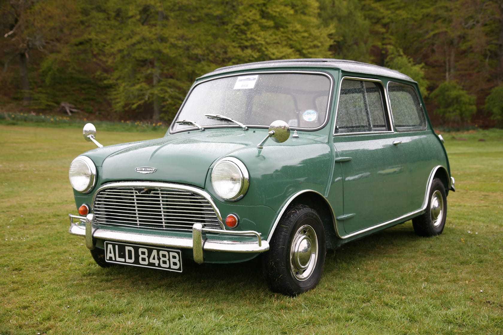 A green and white 1964 Austin Mini Cooper with a UK registration, parked on grass at a show