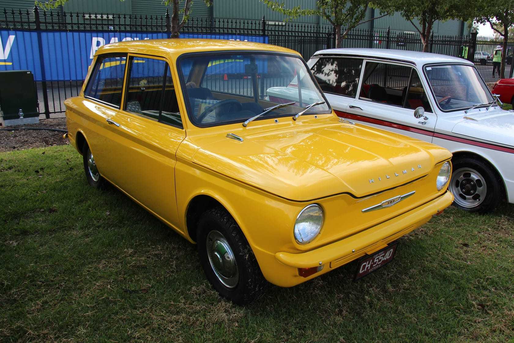 A yellow 1965 Hillman Imp Mk I at a classic car show, front three-quarter view