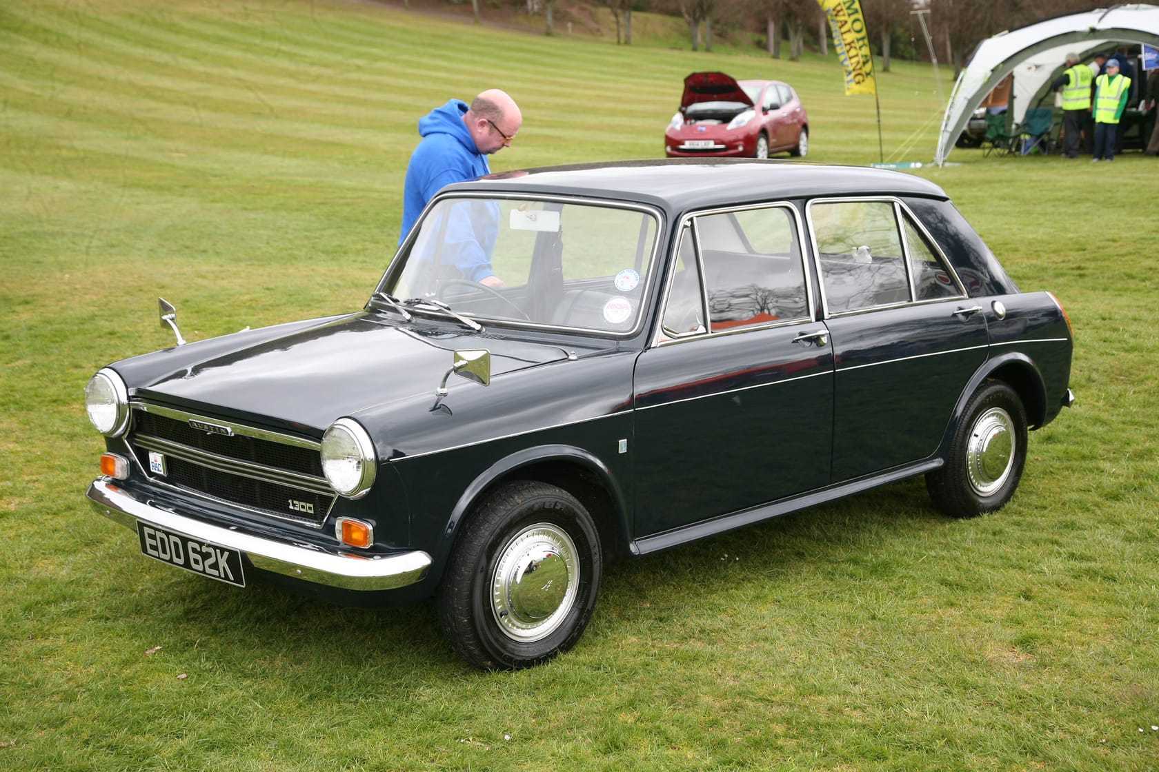 A dark green 1972 Austin 1300 with a black roof at a classic car show, front three-quarter view