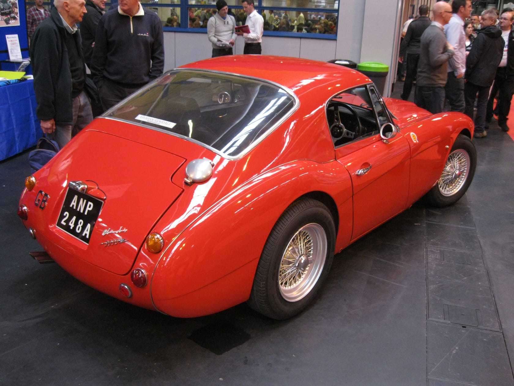 A red Austin-Healey 3000-based coupe with a hardtop, rear three-quarter view