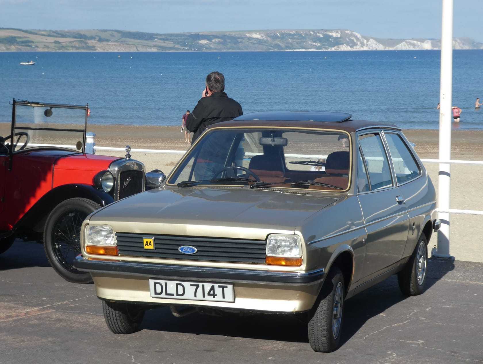 A beige 1979 Ford Fiesta 1.1 Ghia parked on a seaside promenade, UK registration DLD 714T