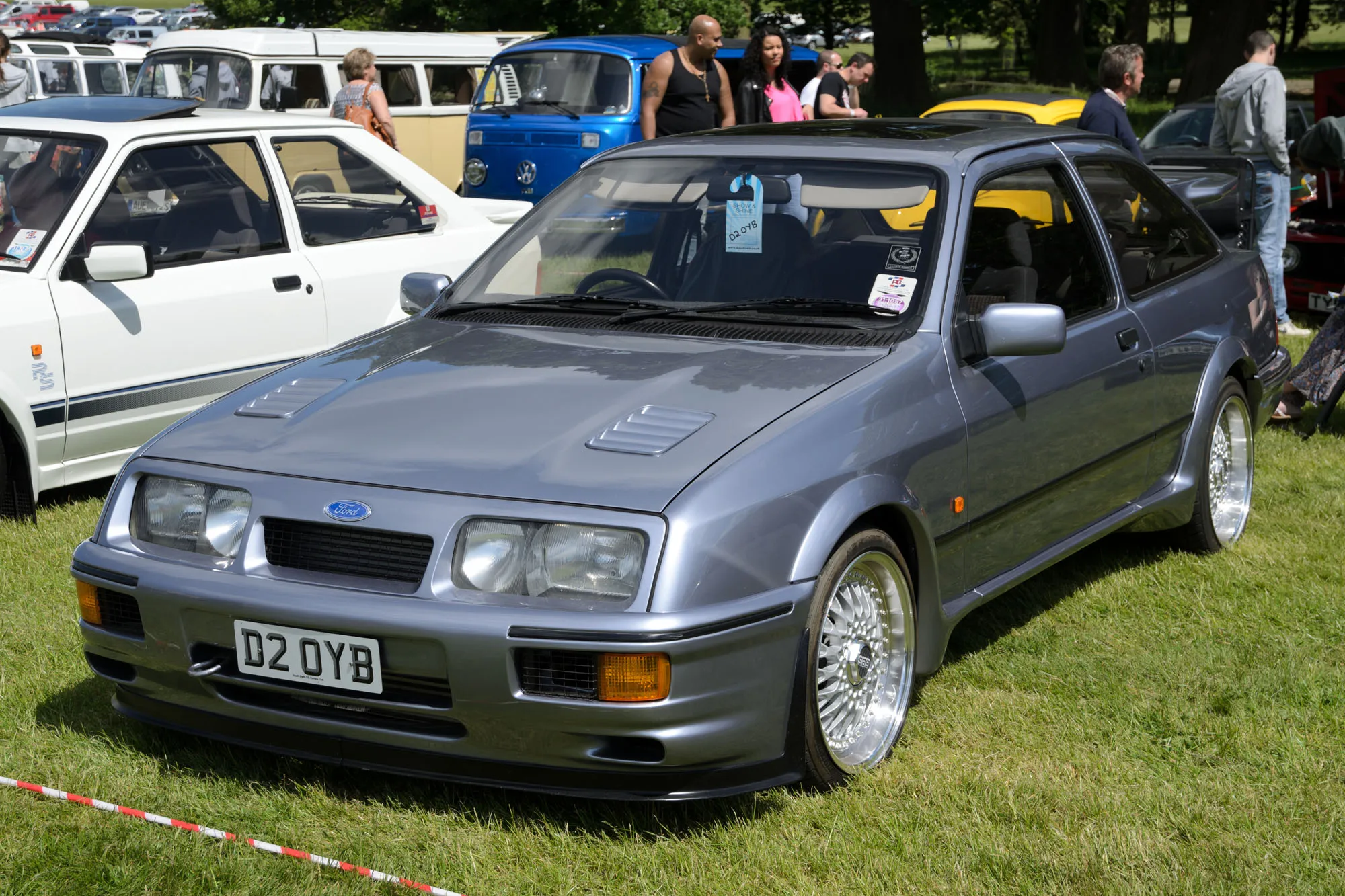 A grey three-door Ford Sierra RS Cosworth with a whale-tail wing, front three-quarter view