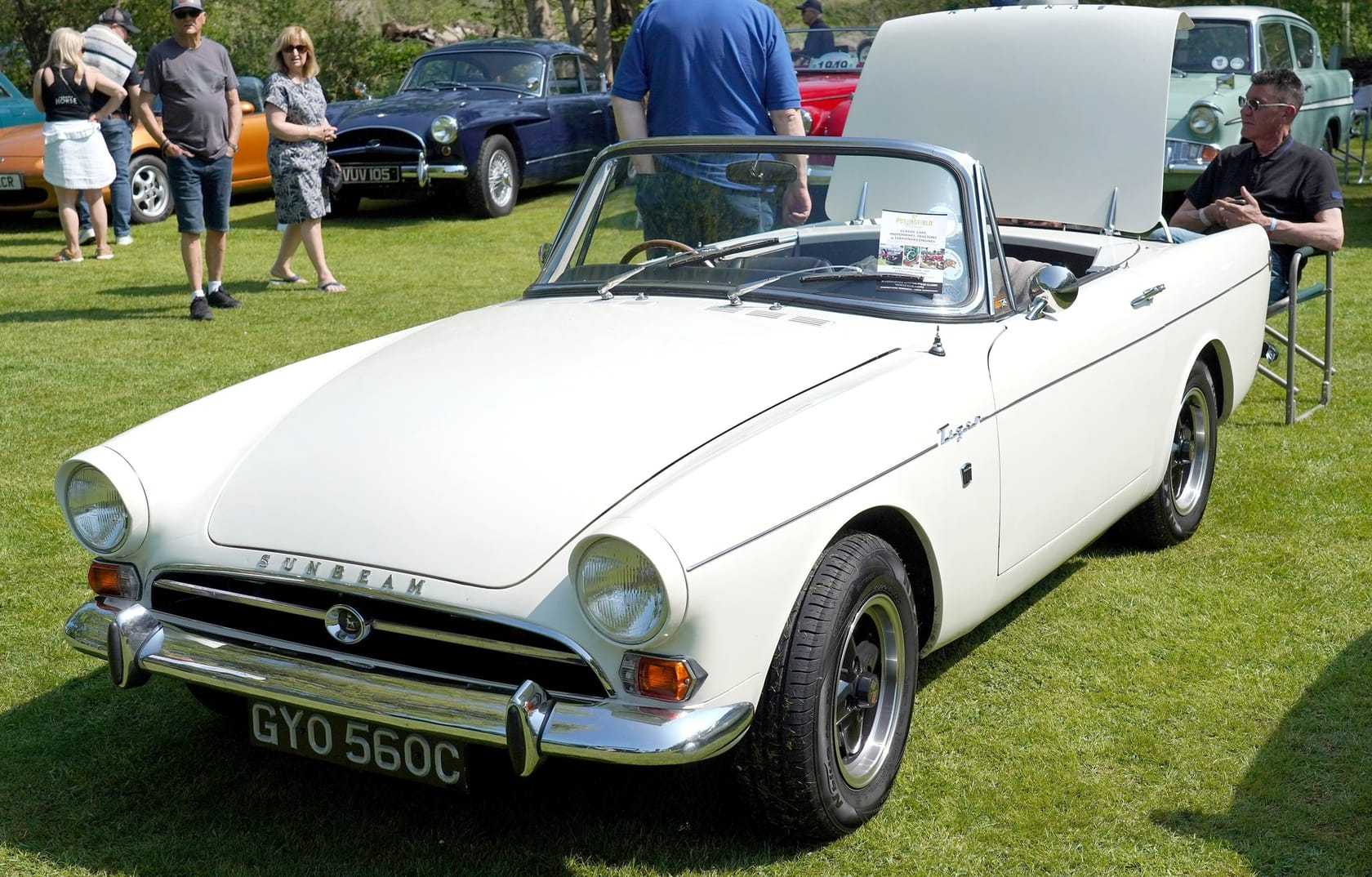 A white Sunbeam Tiger on grass at a show, front three-quarter view, UK registration GYO 560C