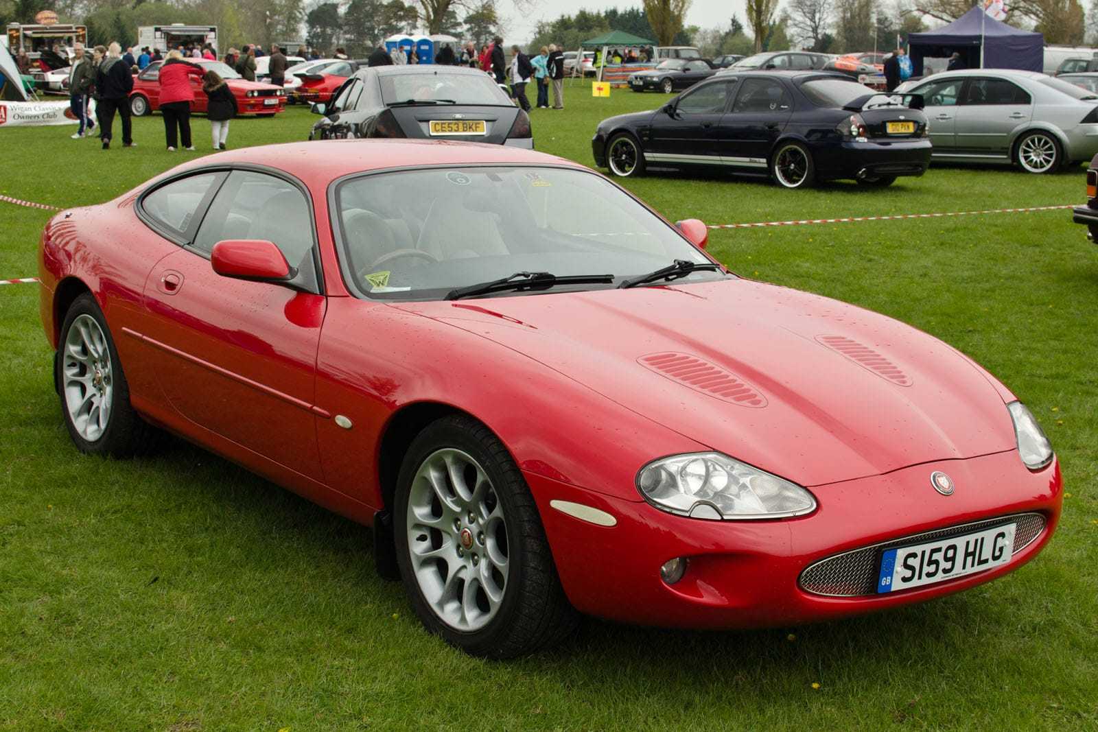 A red 1998 Jaguar XKR with UK registration S159 HLG on a show field