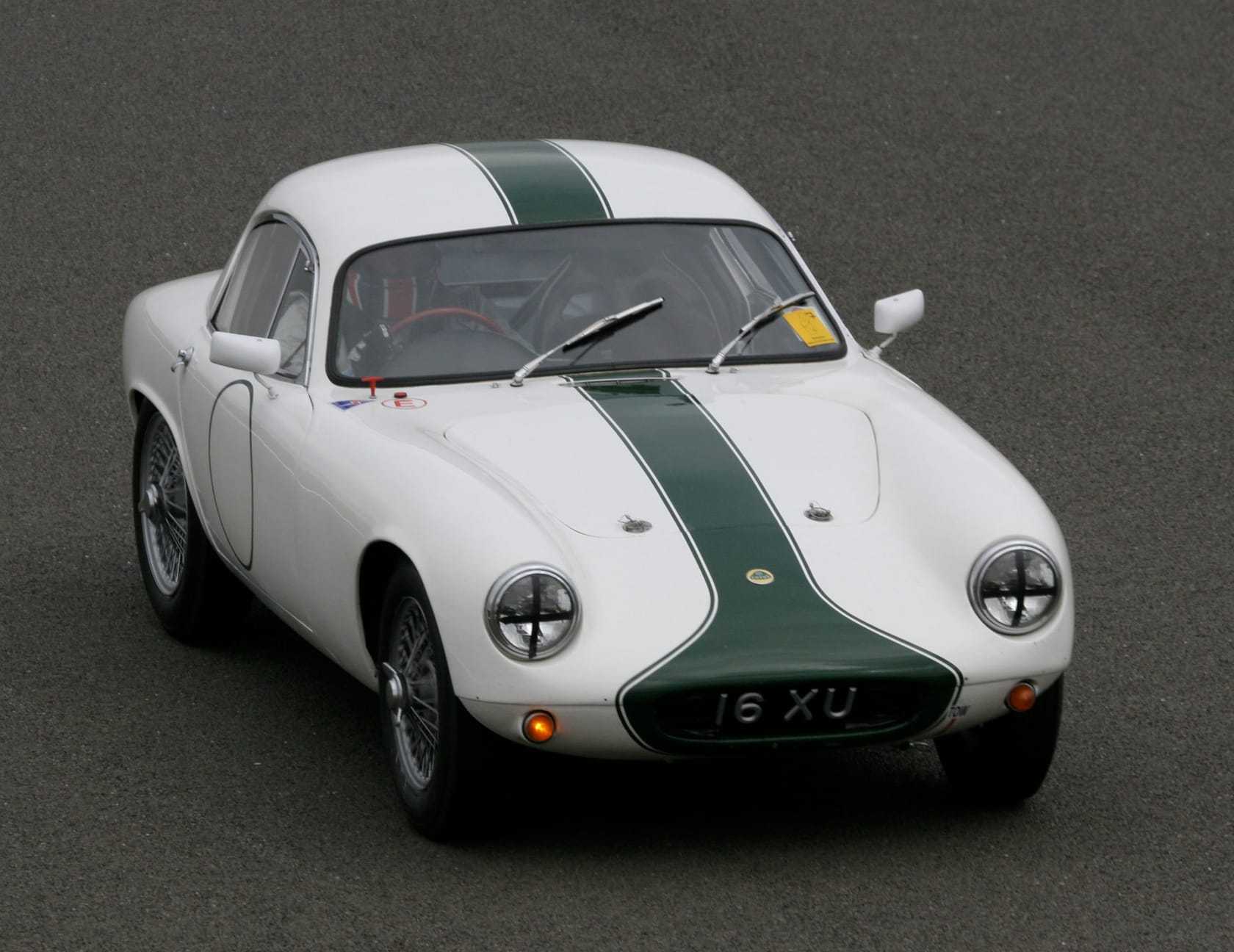 A white Lotus Elite Type 14 with a green centre stripe and registration 16 XU, front three-quarter view on a race circuit