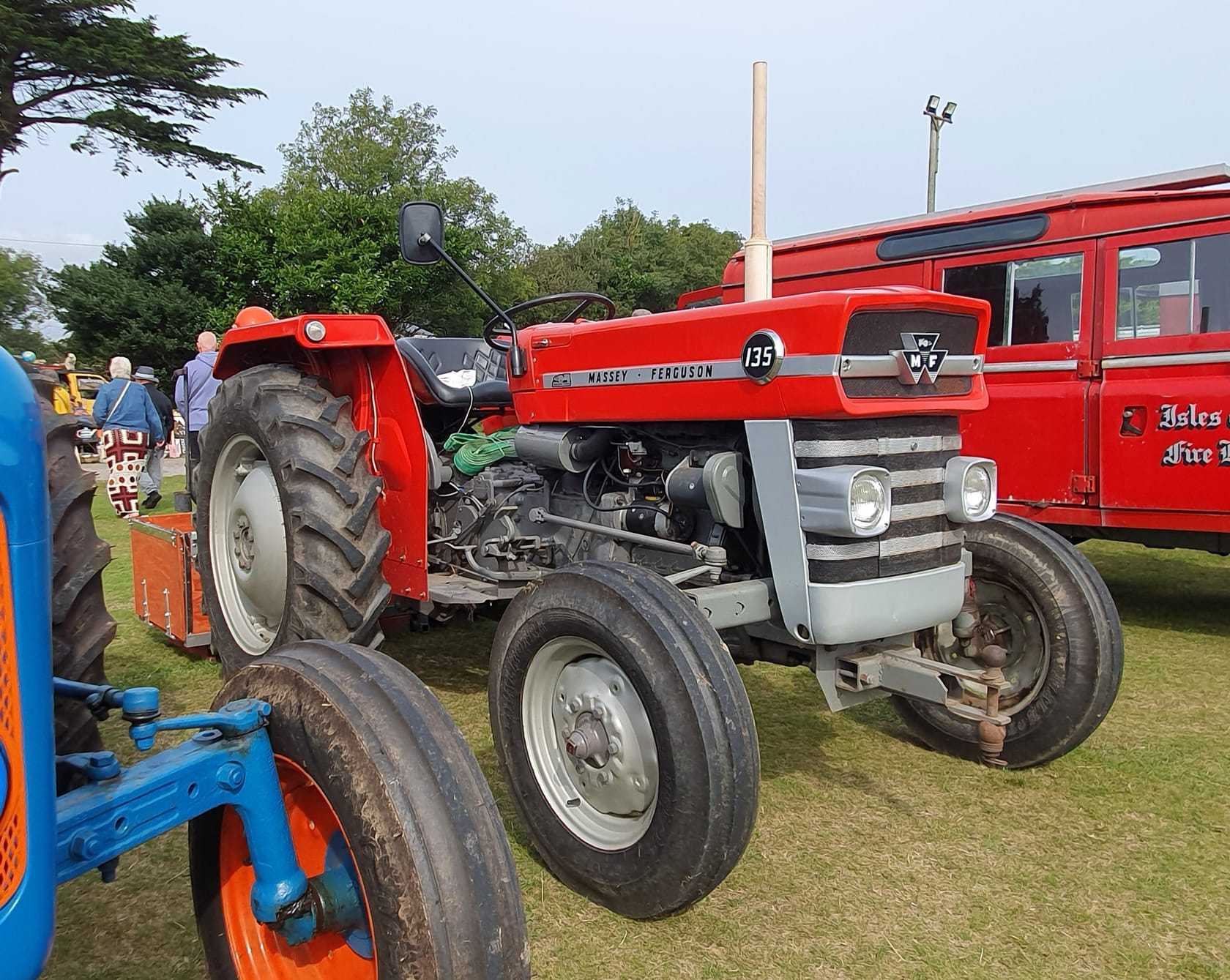 A red Massey Ferguson 135 in a lineup of classic tractors at a Cornish vintage rally