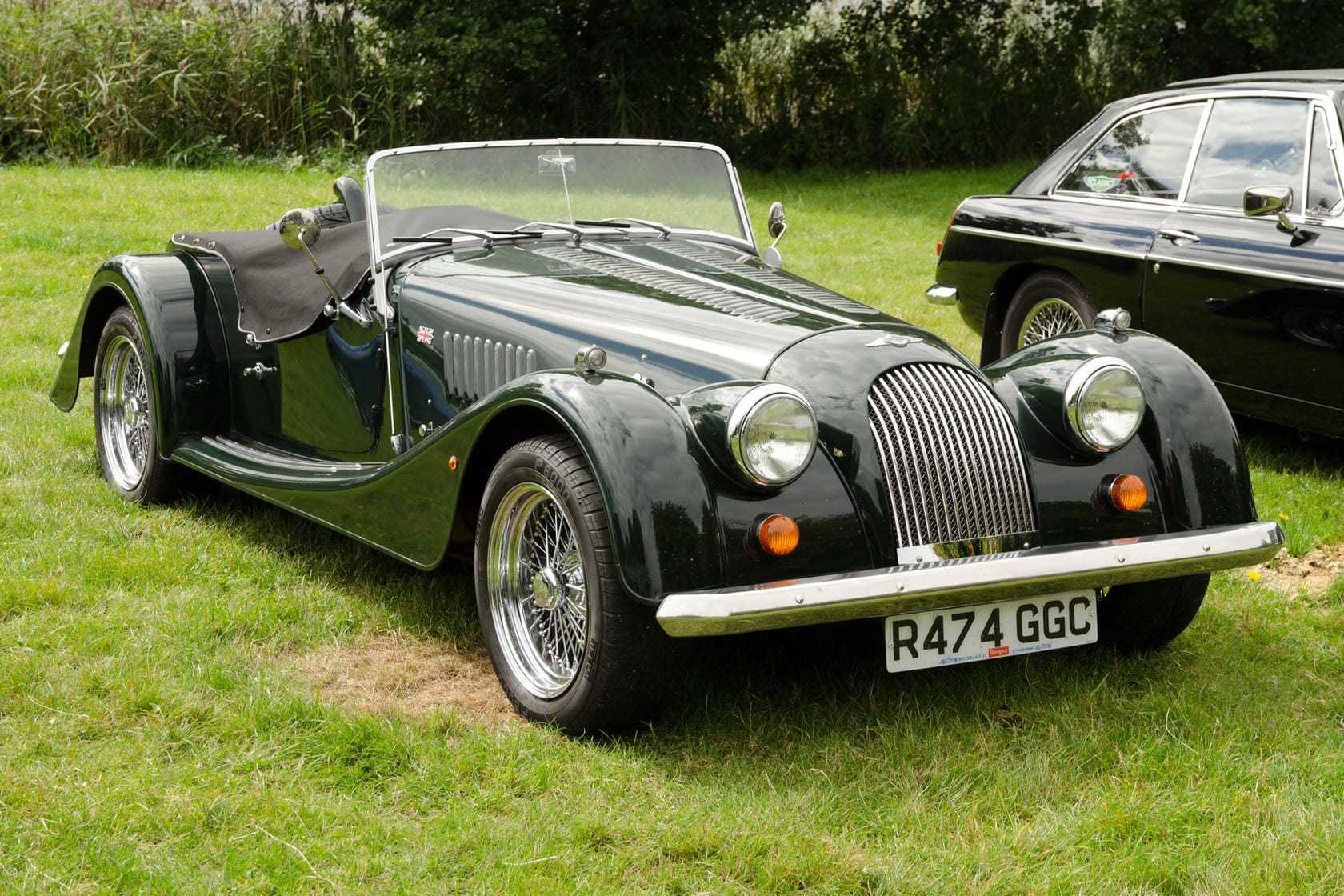 A dark green 1998 Morgan Plus 8 3.9 with UK registration R474 GGC and wire wheels at a classic car show
