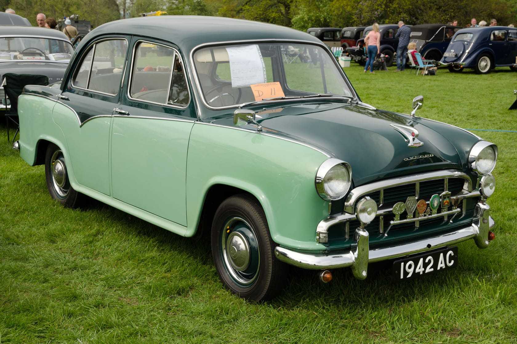 A two-tone green 1958 Morris Oxford Series III saloon at a classic car show, front three-quarter view, UK registration 1942 AC