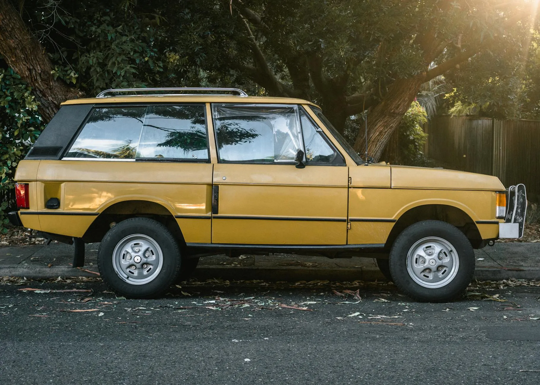 A gold two-door Range Rover Classic in clean side profile at sunset