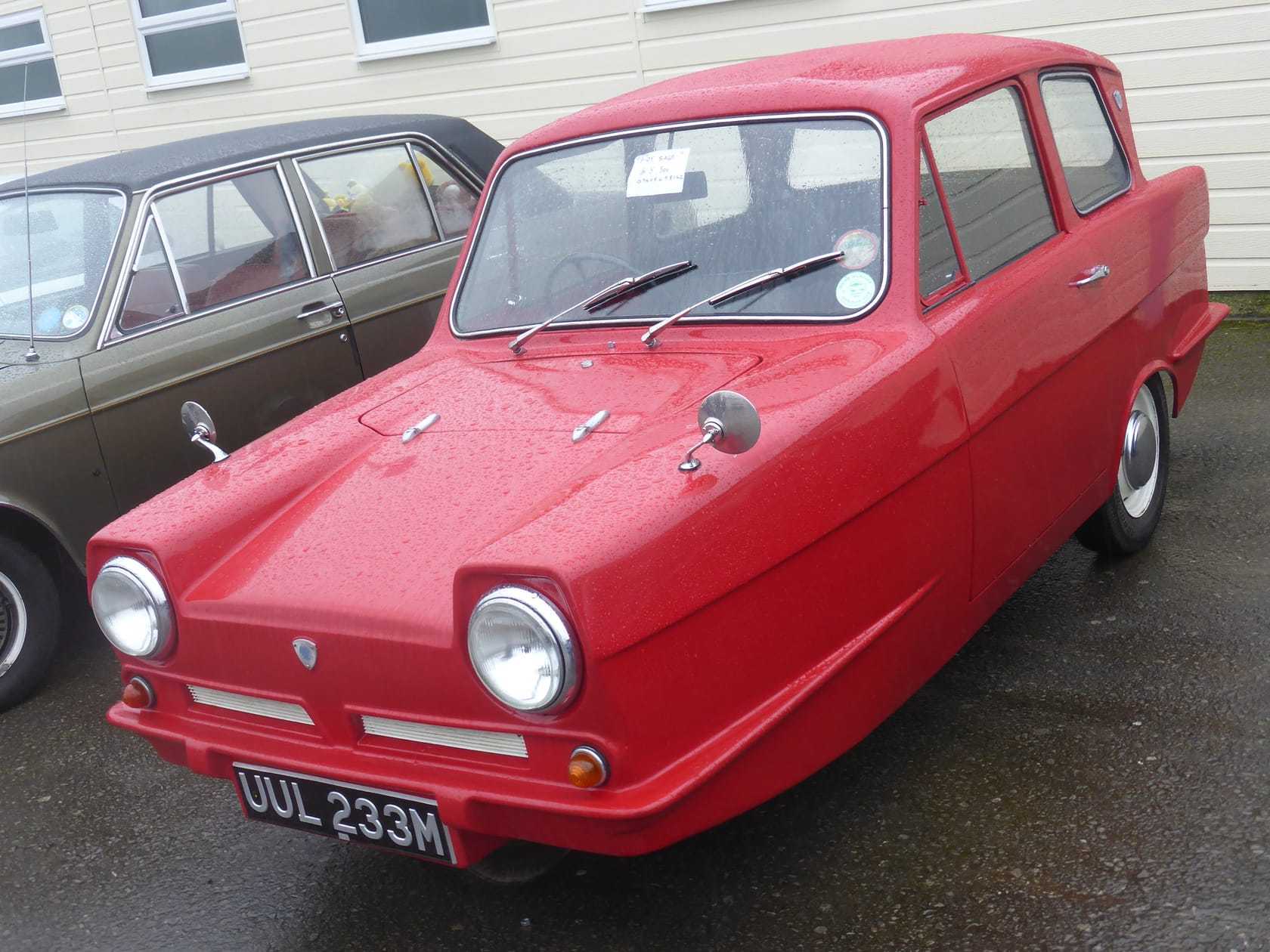 A red 1973 Reliant Regal 21E 700 saloon, front three-quarter view, UK registration OUL 233M