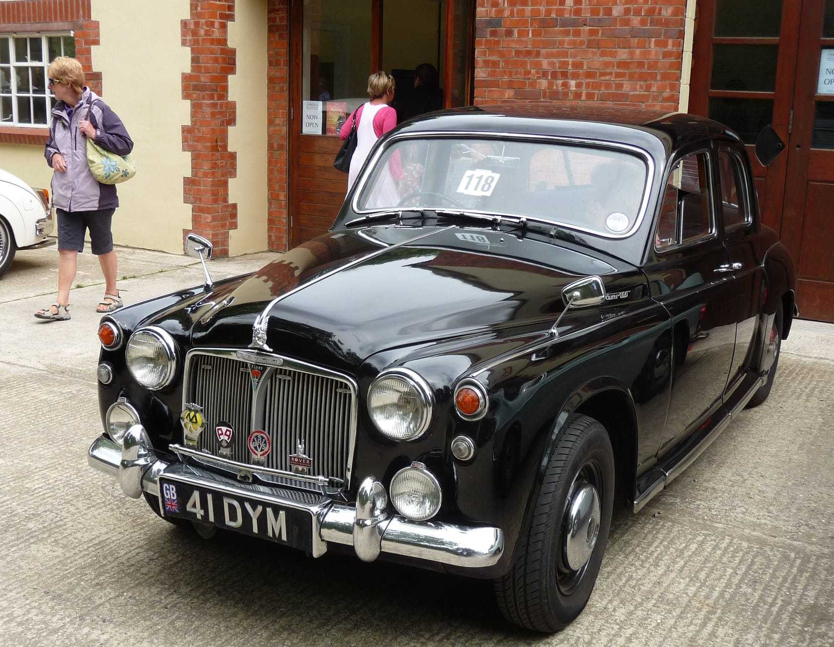 A black Rover P4 100 outside a brick building at a classic car event, front three-quarter view, UK registration 41 DYM