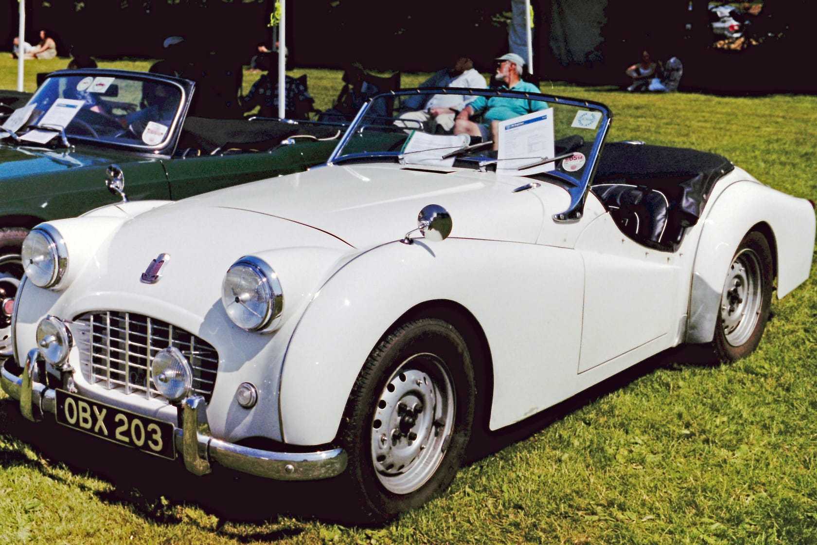 A white 1957 Triumph TR3 small-mouth with a UK registration on a show field