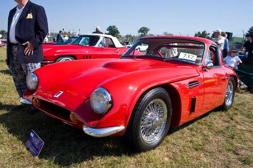 A red 1960s TVR Griffith 400 at a classic car show, front three-quarter view