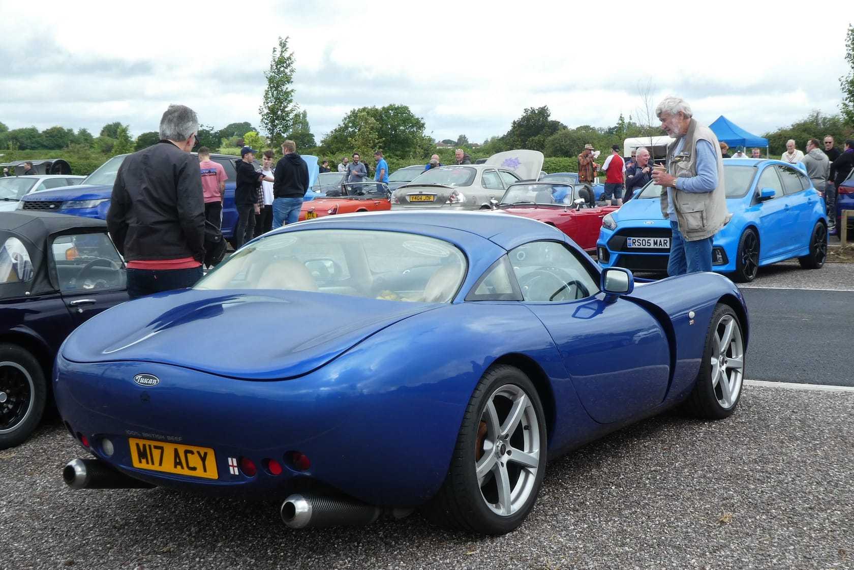 A blue 2001 TVR Tuscan Speed Six with UK registration W17 ACY, rear three-quarter view at a car meet