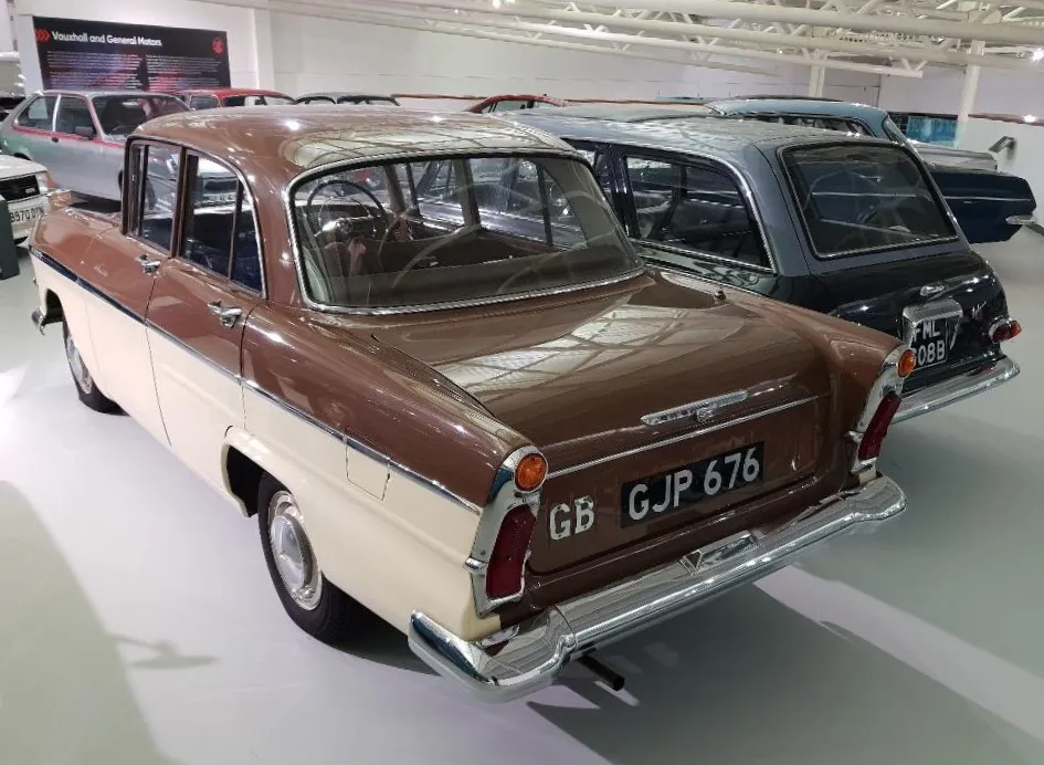 A two-tone brown-and-cream Vauxhall Victor F-Type Series II Deluxe (1960), rear three-quarter view in a museum hall