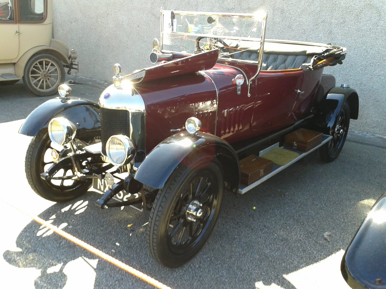 A maroon 1923 Morris Bullnose Oxford tourer with brass fittings and a folded hood, front three-quarter view