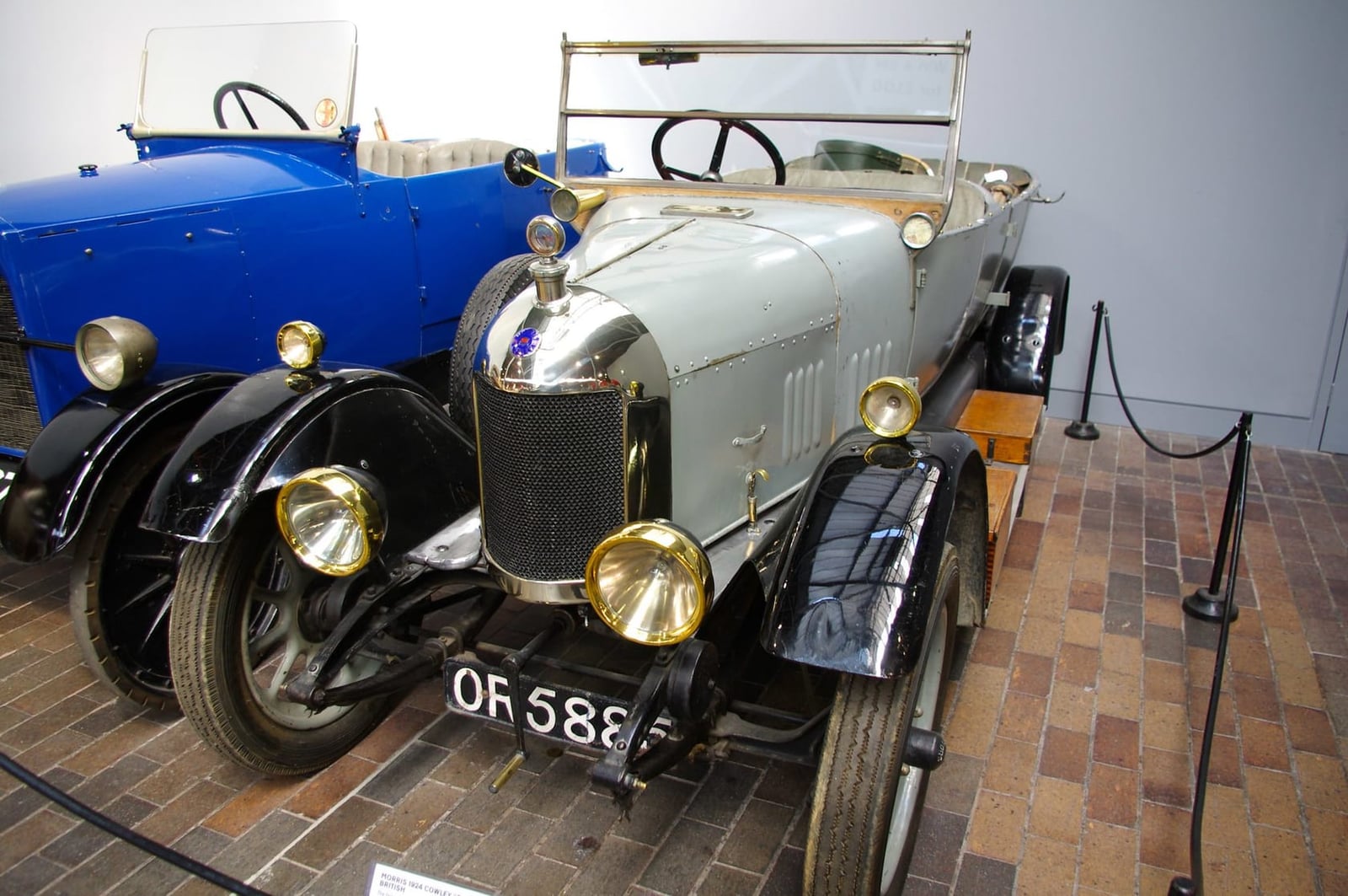 A grey 1924 Morris Cowley Bullnose tourer with brass lamps on museum display, UK registration OR 5885