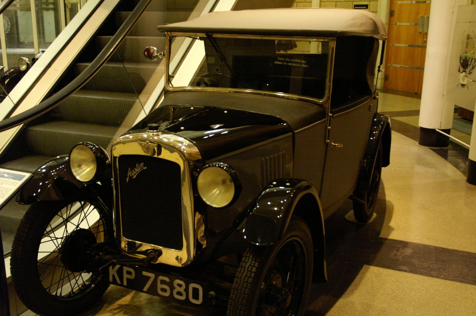 A red Austin Seven tourer of 1933 with its bonnet open, showing the small four-cylinder engine