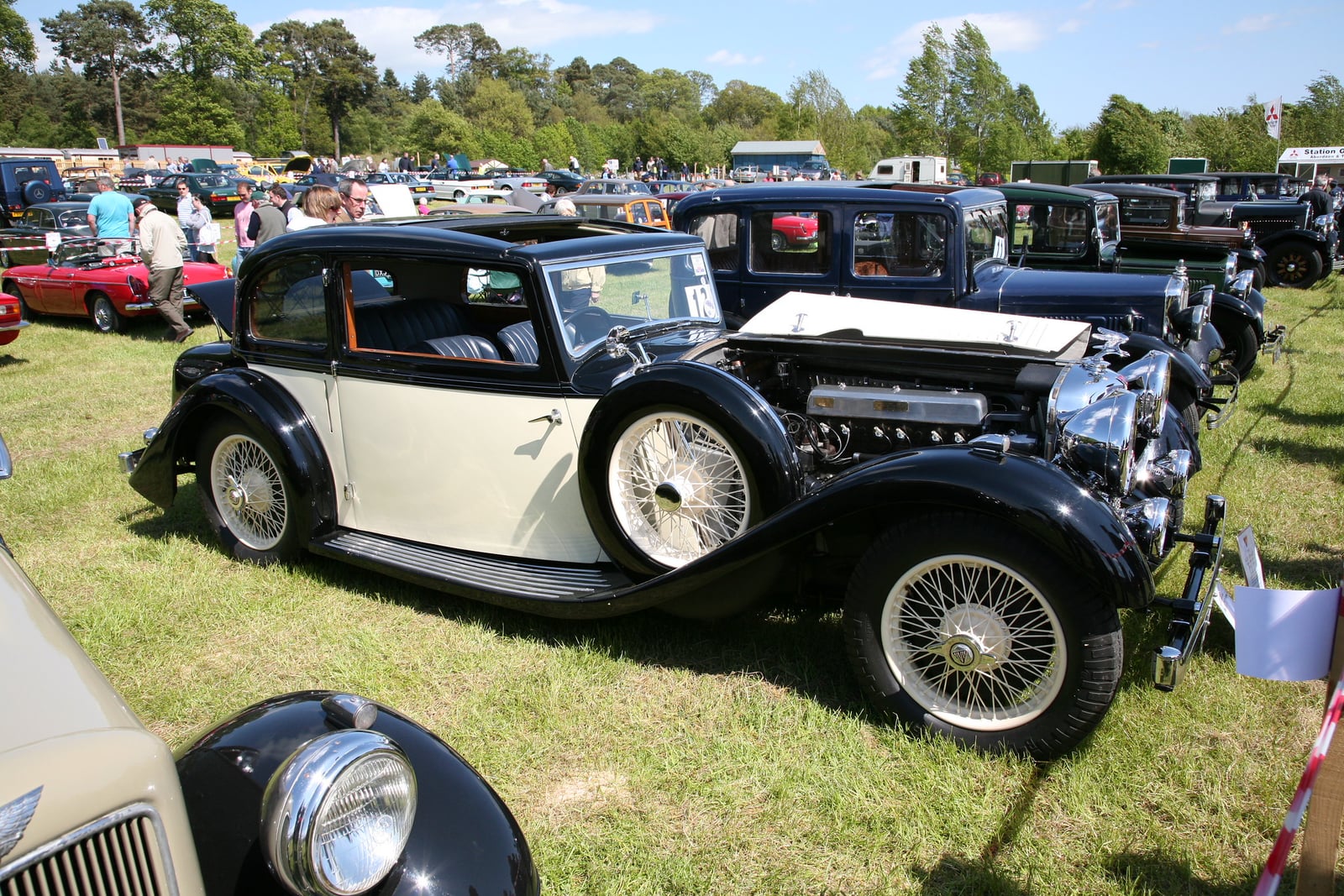 A two-tone Alvis Speed 20 coachbuilt saloon at a show, side view, bonnet open