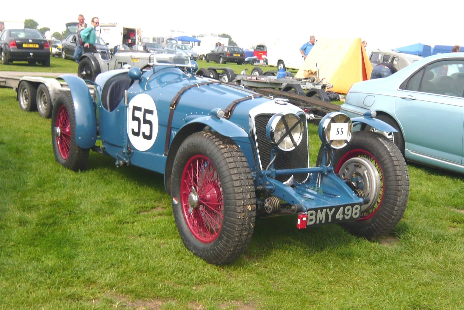 A blue 1934 Riley Kestrel 12/4 rebuilt as a racing special, carrying race number 55, on grass at a motorsport event, UK registration BMY 498