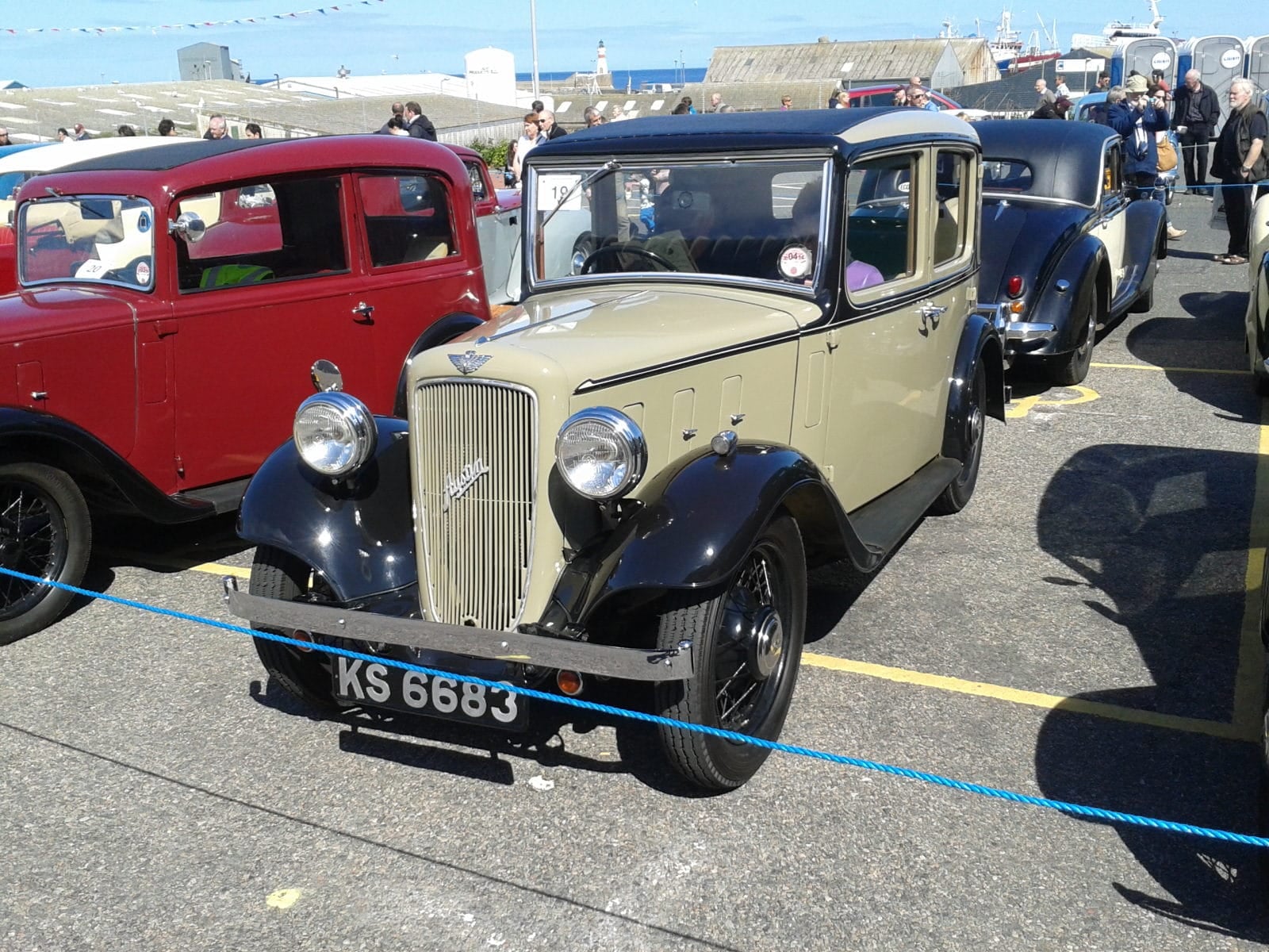 A cream and black 1935 Austin Ten Lichfield saloon at a classic vehicle gathering, front three-quarter view, UK registration KS 6683