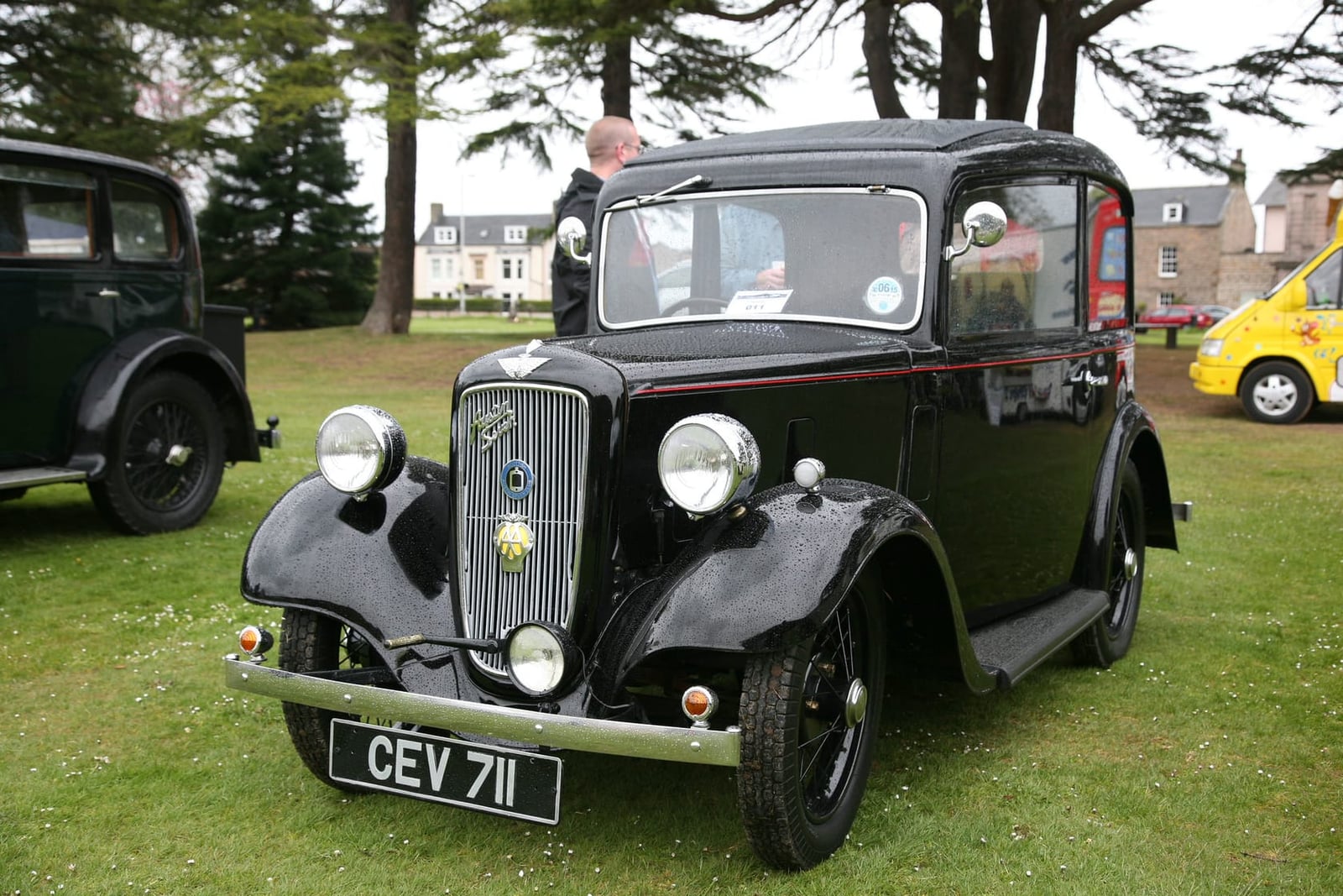 A black 1935 Austin Seven Ruby saloon with a UK registration on grass at a show