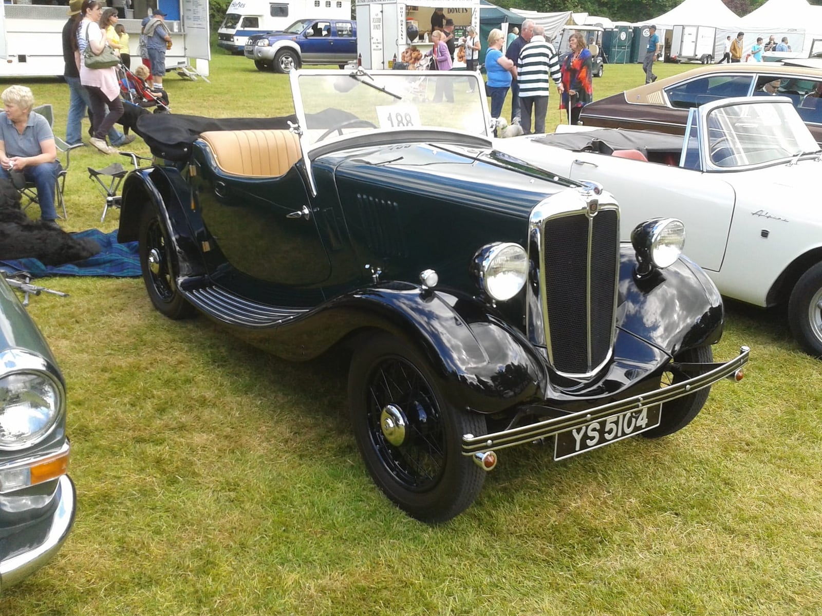 A black Morris Eight Series E saloon at a classic vehicle rally, front three-quarter view, UK registration HKB 146