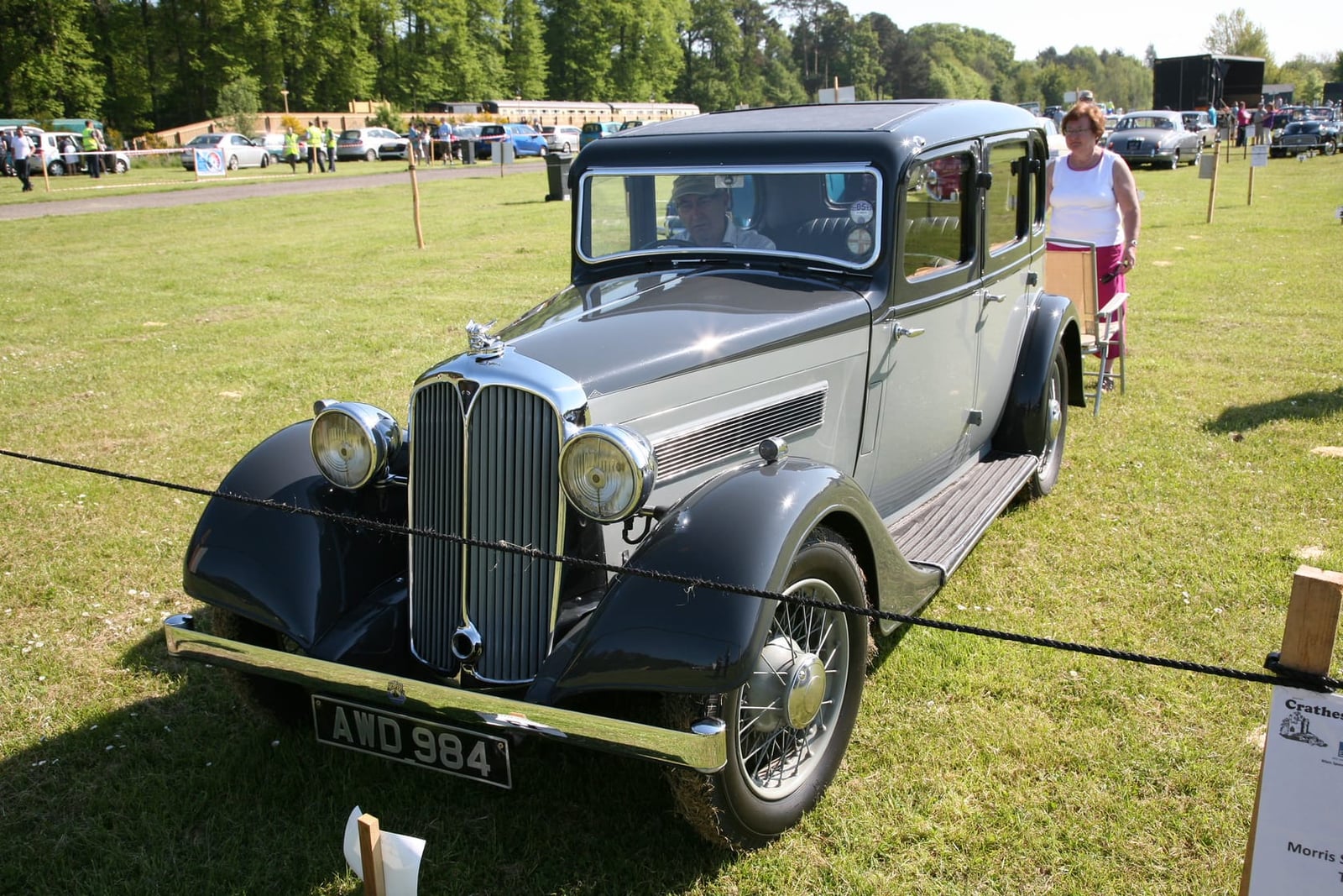 A grey and black 1936 Rover 10 saloon on grass at a classic car rally, front three-quarter view, UK registration AWD 984
