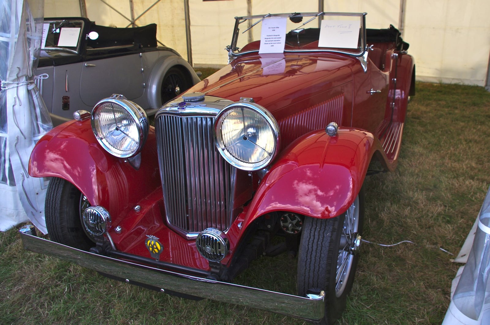 A maroon SS Jaguar tourer at a show, front three-quarter view