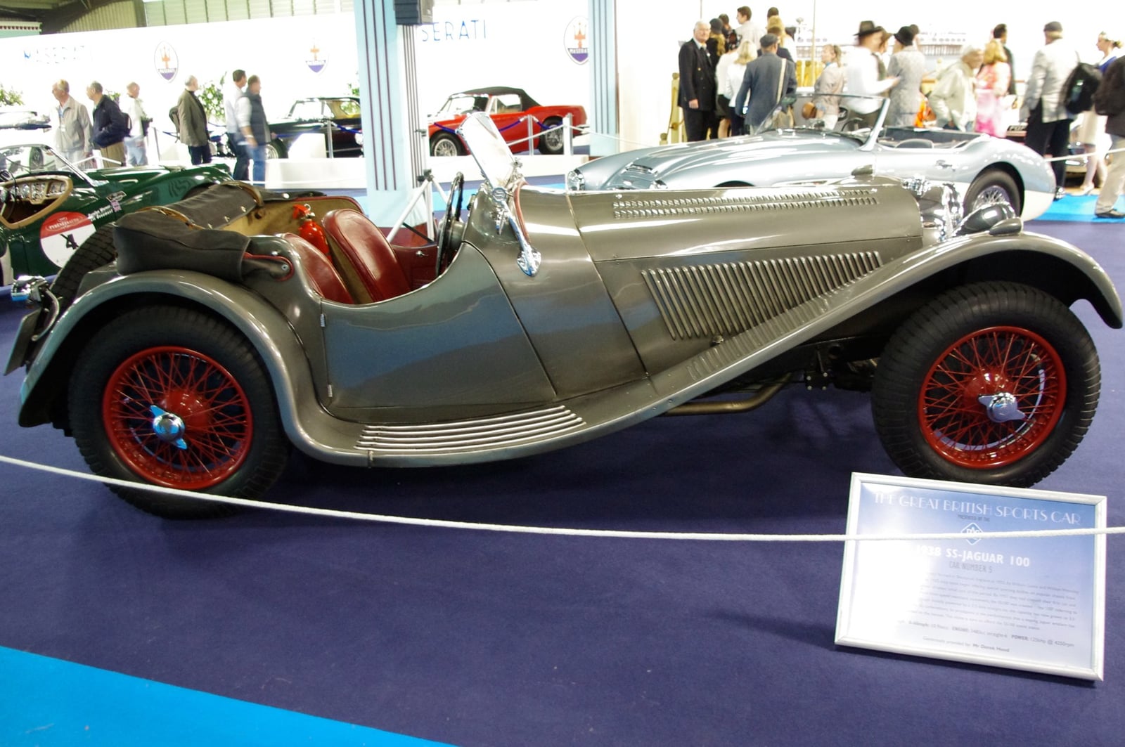 A silver SS Jaguar 100 open sports car in profile at a show