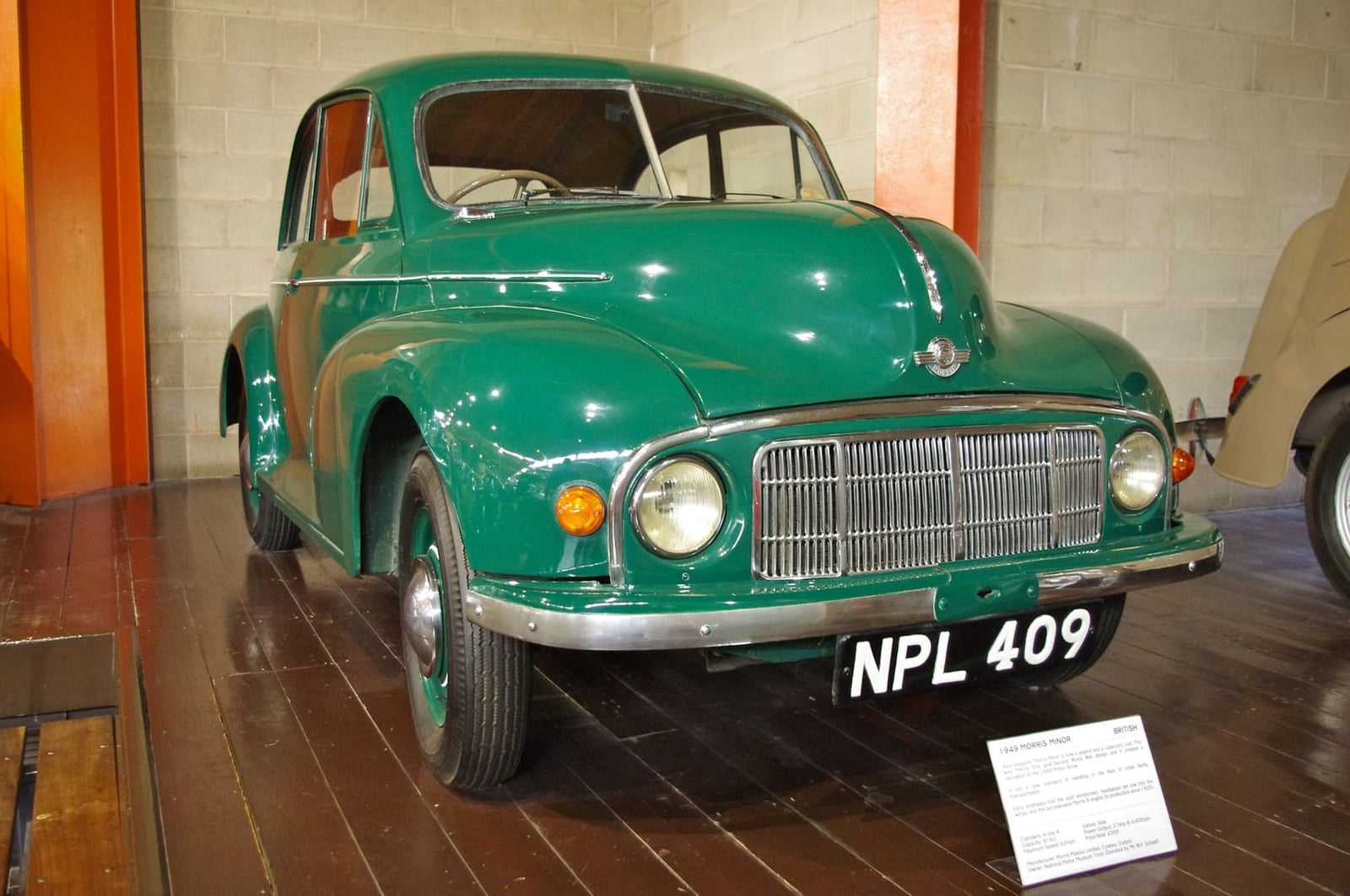 A green 1949 Morris Minor MM series with headlamps set low in the grille, on museum display, UK registration NPL 409