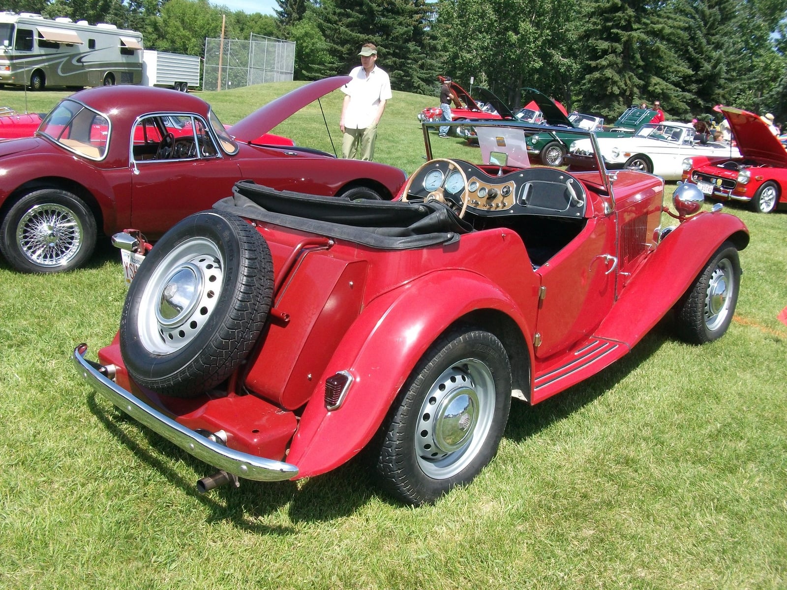 A red MG TD of 1950 at a show, front three-quarter view