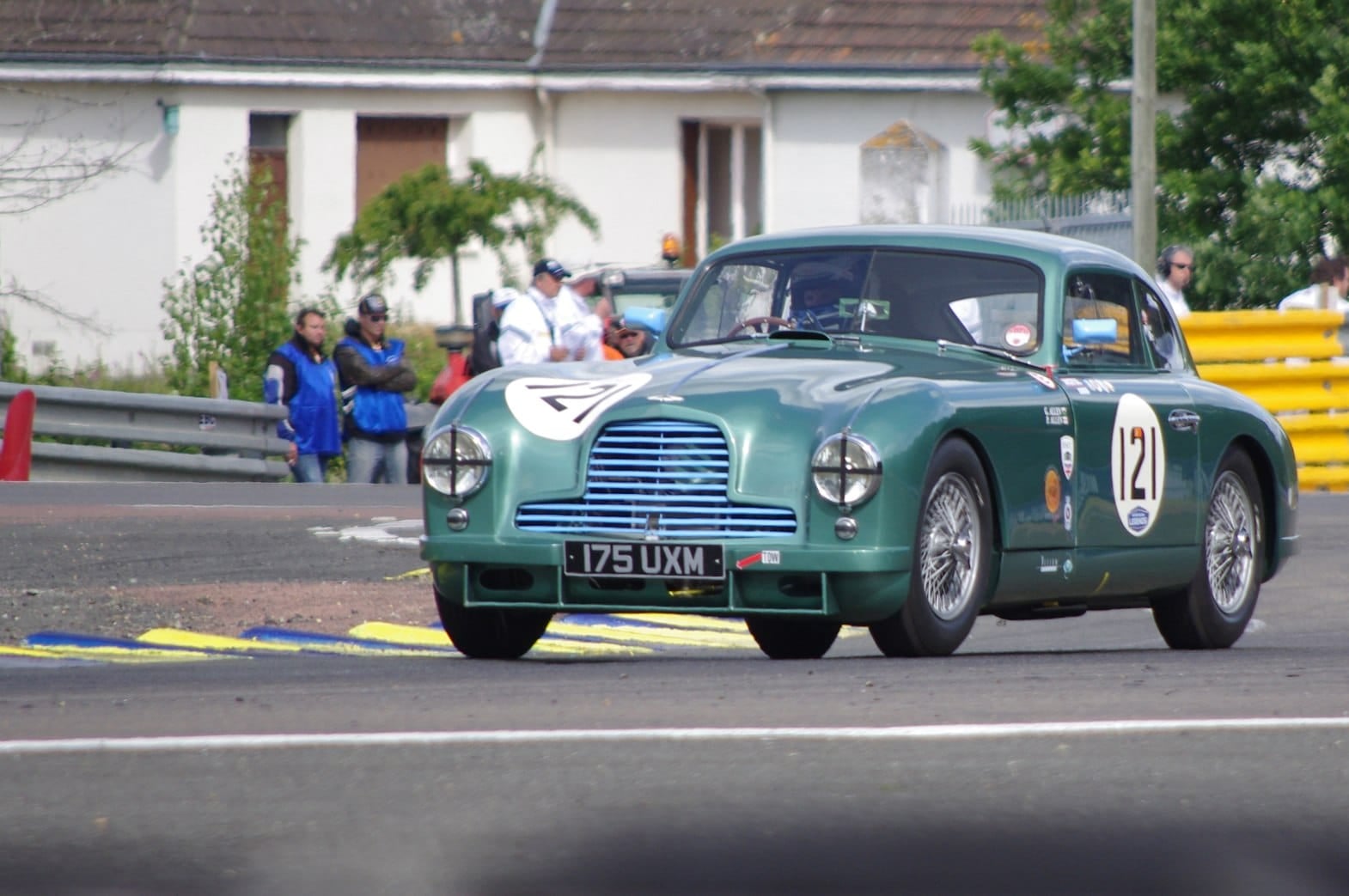 A green 1951 Aston Martin DB2 with racing number 21 and UK registration 175 UXM on a race circuit