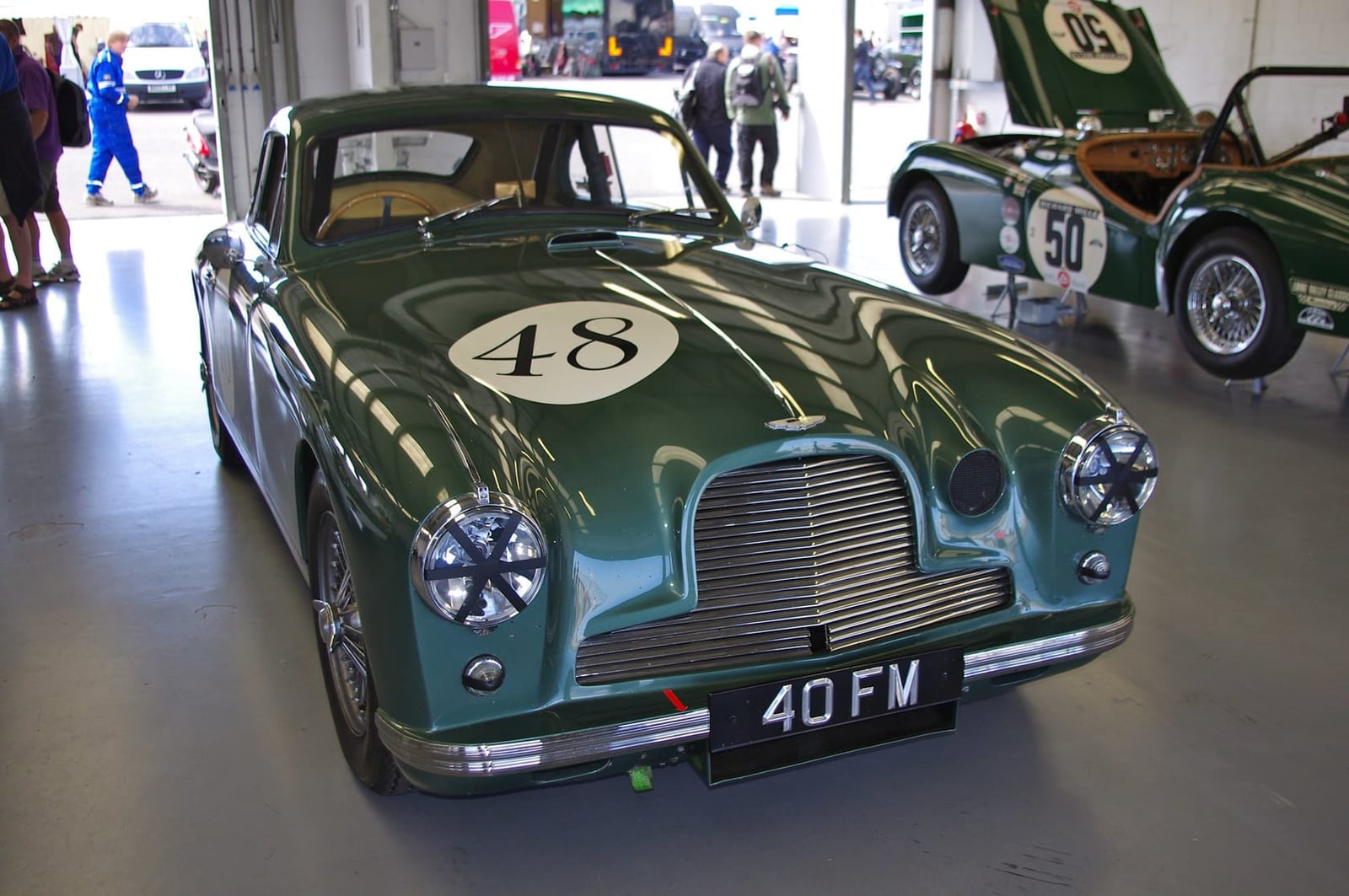 A green 1952 Aston Martin DB2 with racing number 48 and UK registration 40 FM displayed in a museum