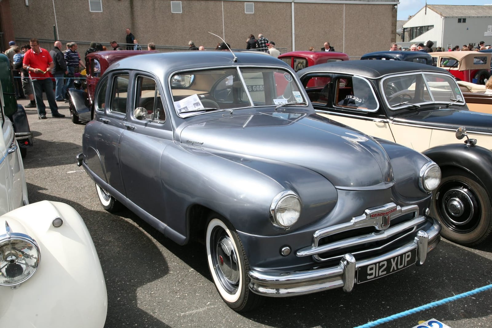 A grey-blue Standard Vanguard Phase I at a classic car gathering, front three-quarter view, UK registration 912 XUP