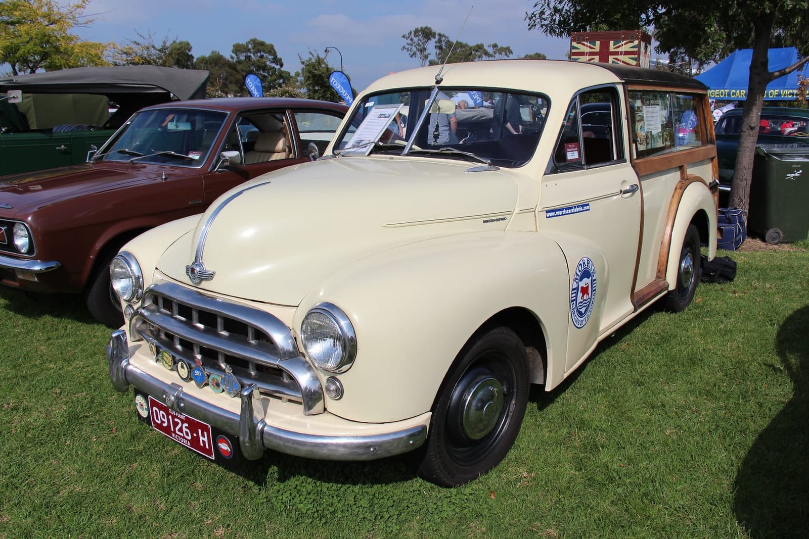 A cream 1953 Morris Oxford MO Traveller with wood-framed rear bodywork at a classic car show