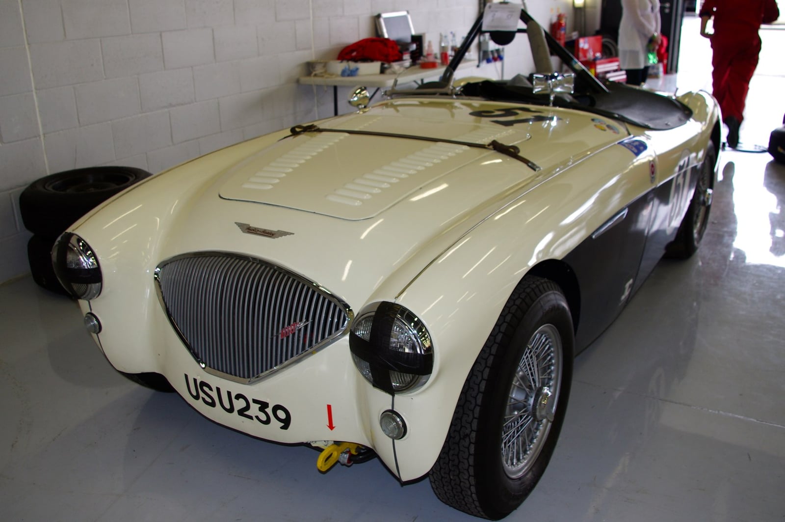 A cream four-cylinder Austin-Healey 100 with wire wheels