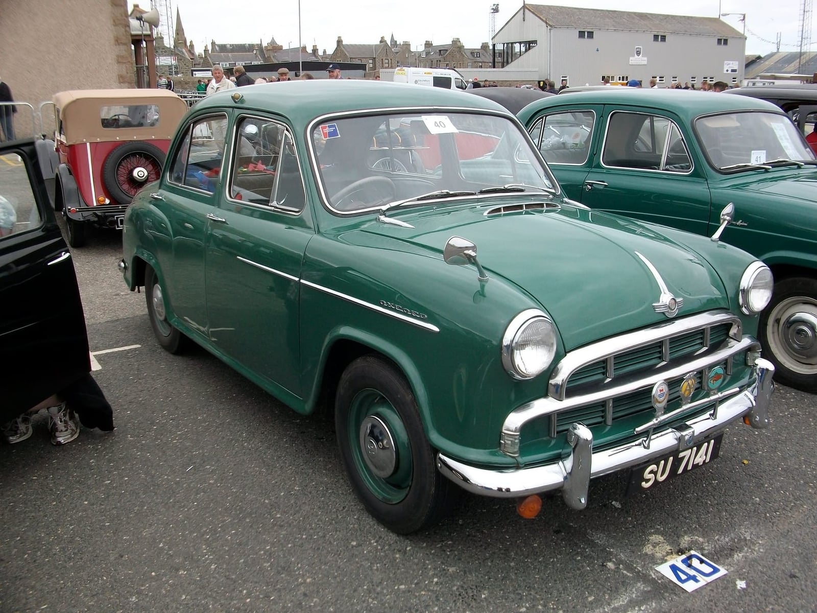 A green 1955 Morris Oxford saloon at a classic car show, front three-quarter view, UK registration SU 7141