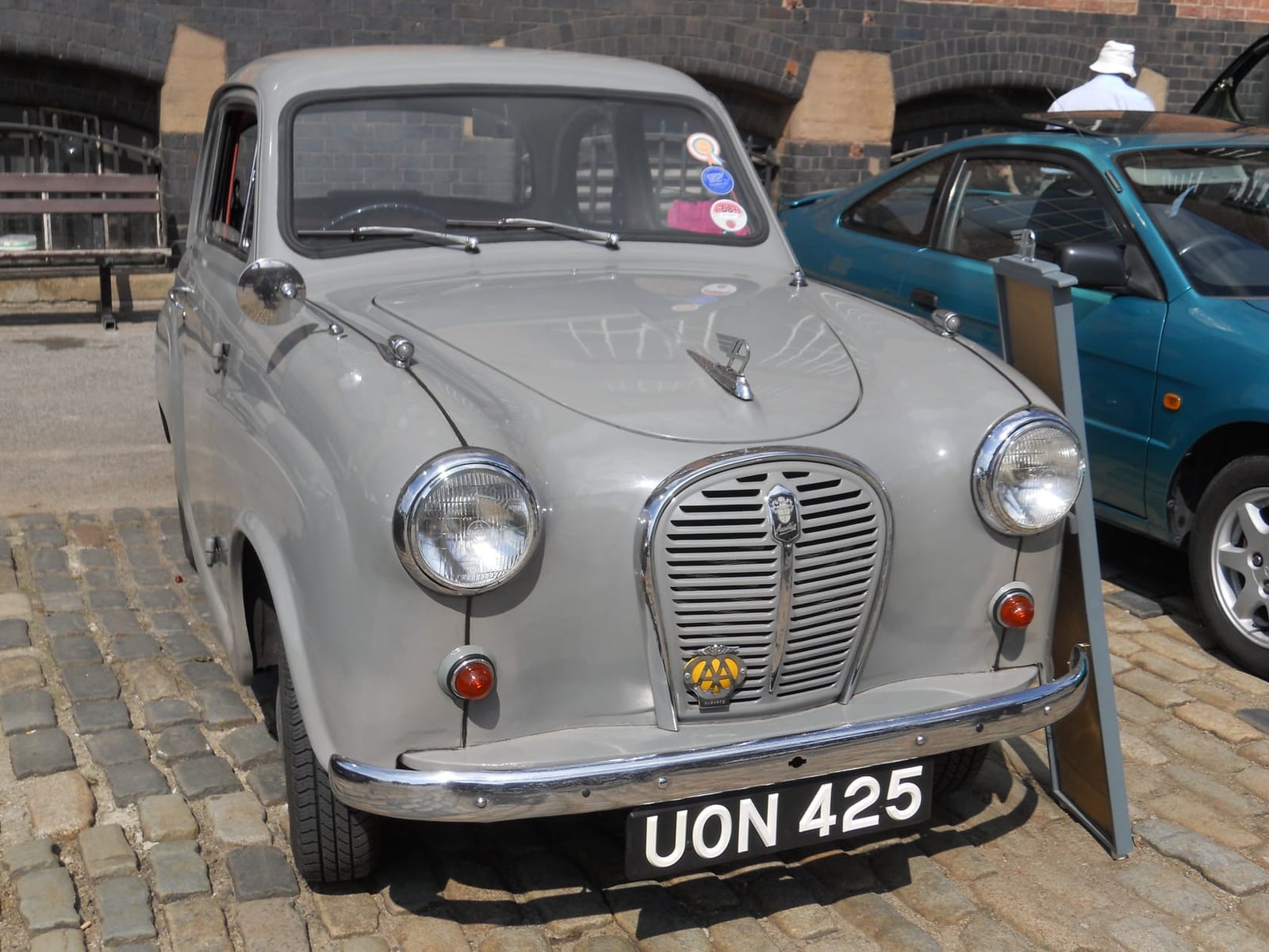 A grey 1957 Austin A35 parked on cobbles, front three-quarter view, UK registration UON 425