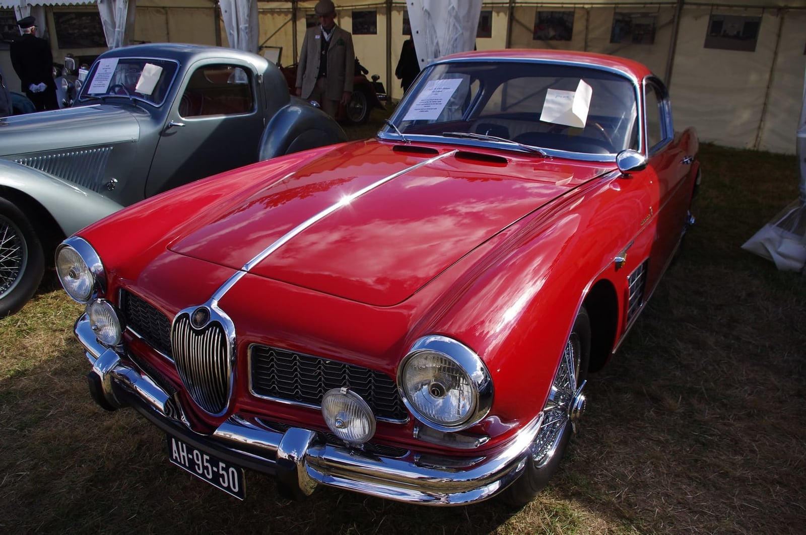 A red 1958 Jaguar XK150 3.8 coupe rebodied by Bertone, on indoor display, front three-quarter view