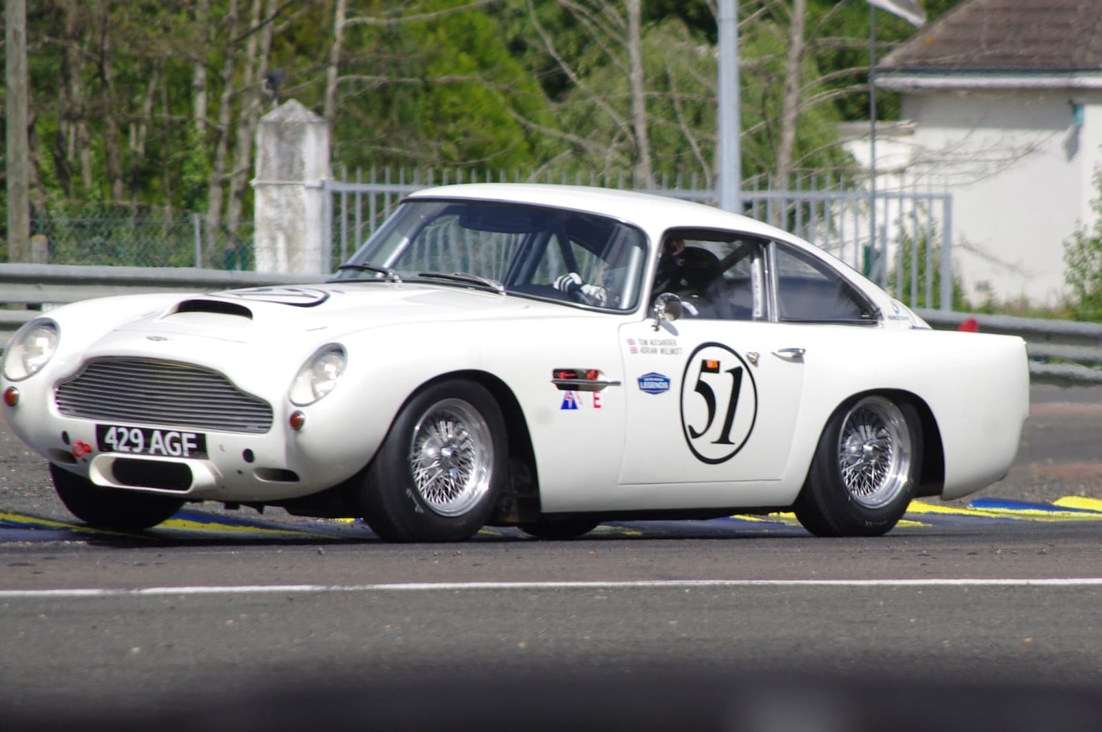 A white 1960 Aston Martin DB4 GT with racing number 51 and UK registration 429 AGF on a circuit