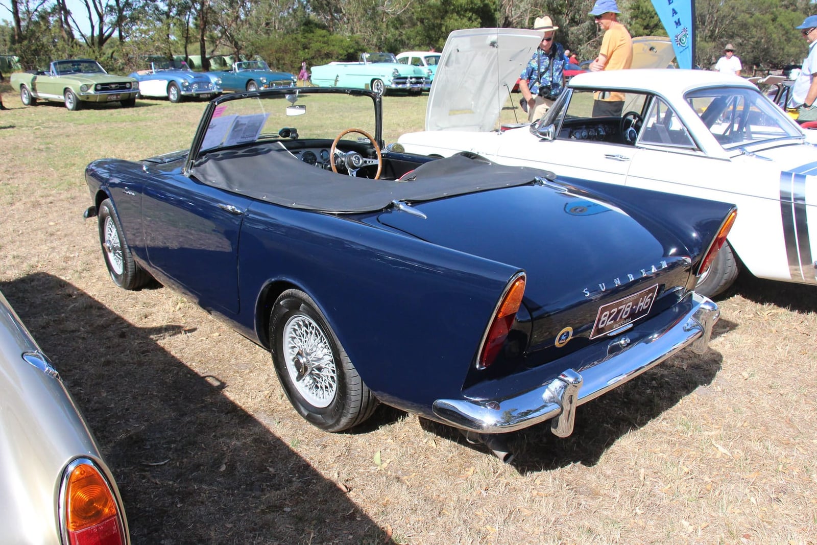 The rear three-quarter of a dark blue 1960 Sunbeam Alpine Series II showing its tailfins