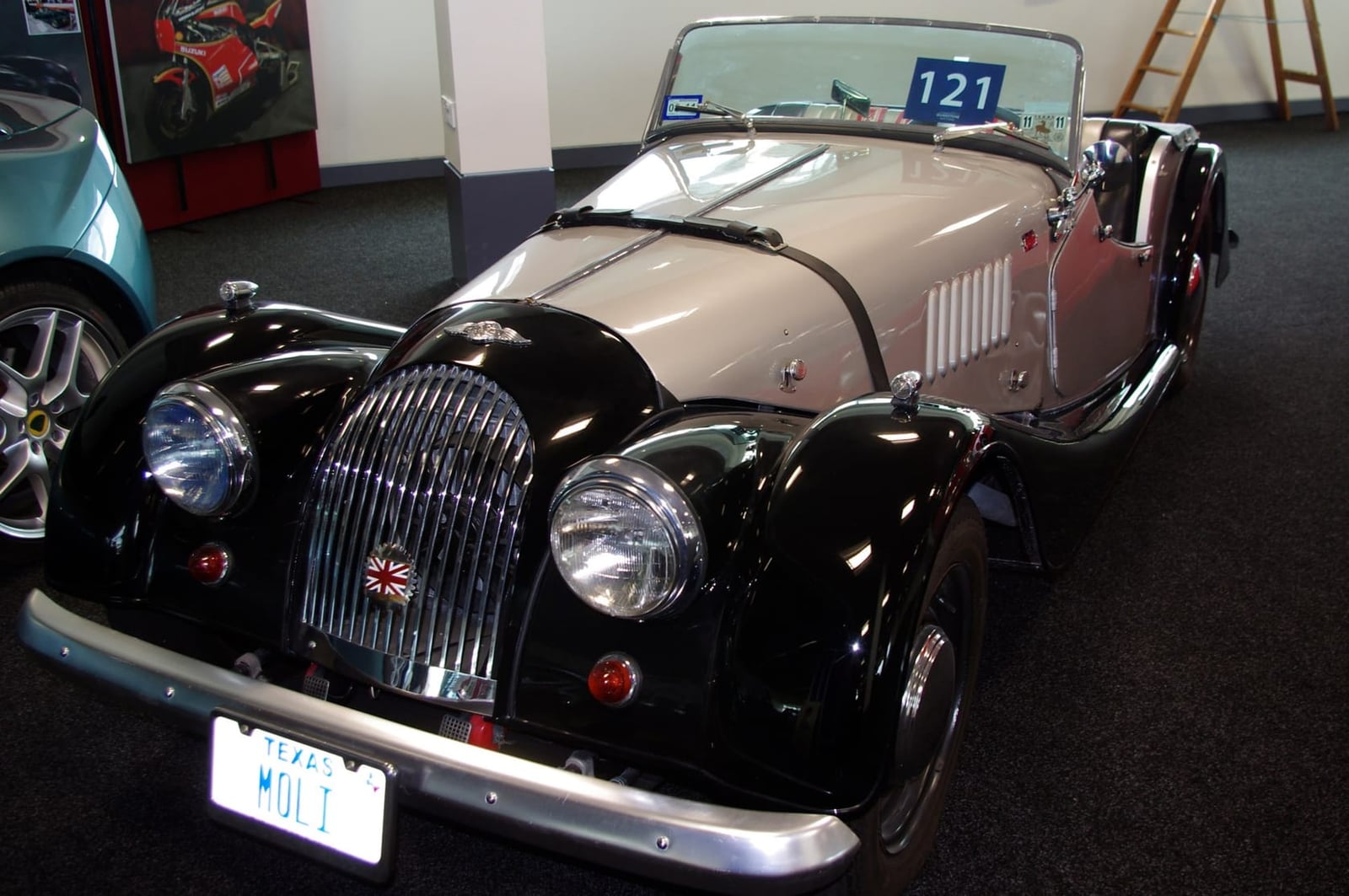 A black 1961 Morgan 4/4 displayed in a museum