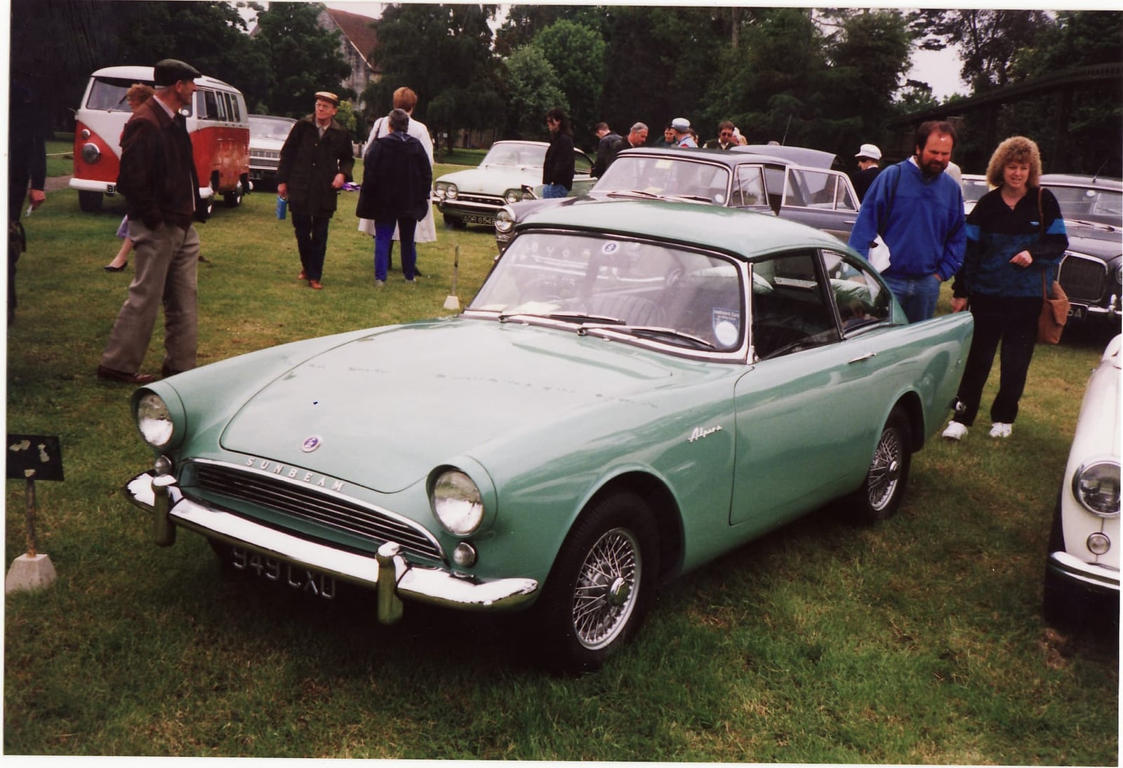 A mint green 1961 Sunbeam Harrington Alpine with darker fastback roof at a period gathering