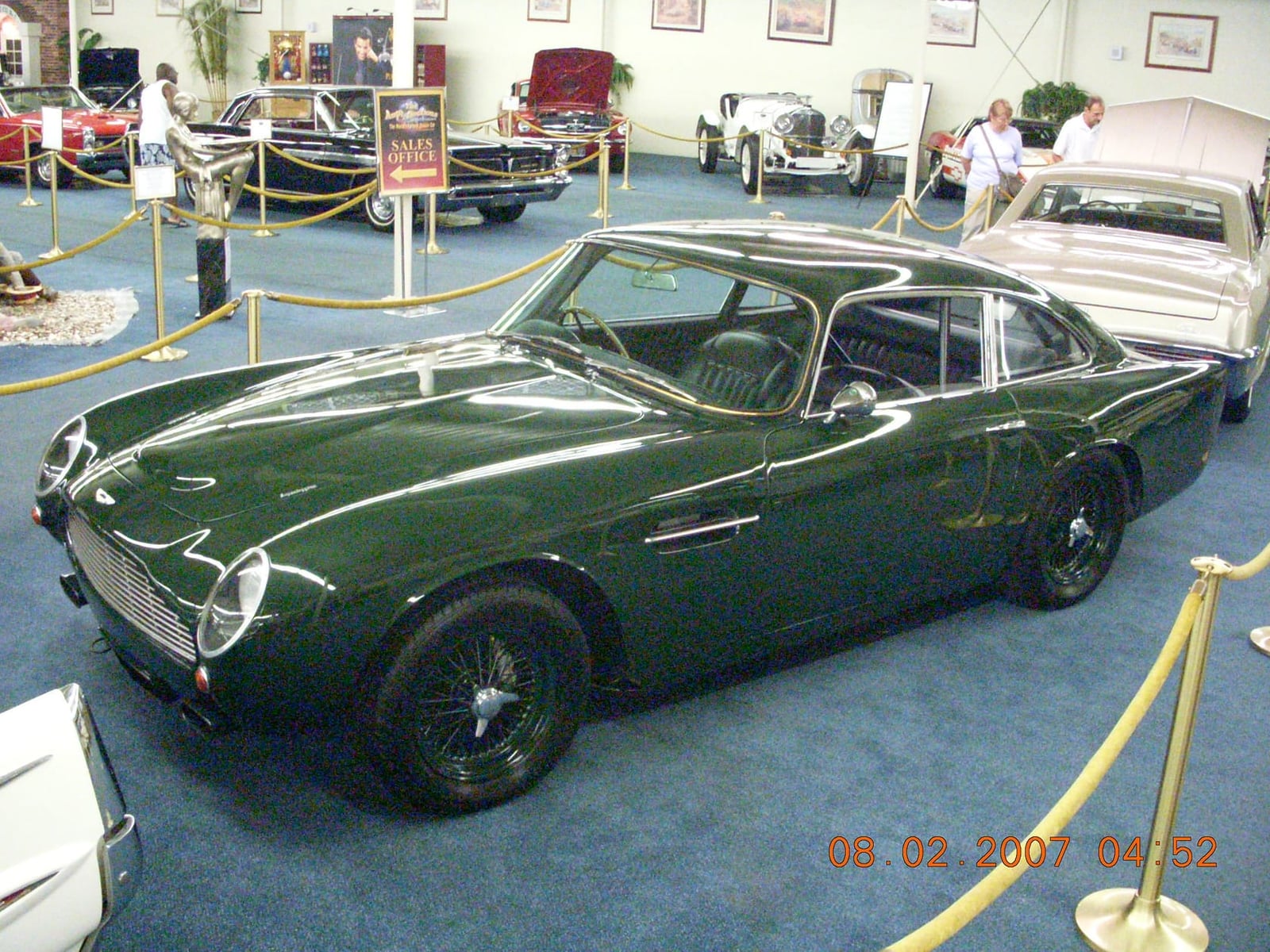 A green 1962 Aston Martin DB4 Series 5 Vantage GT displayed in a museum collection