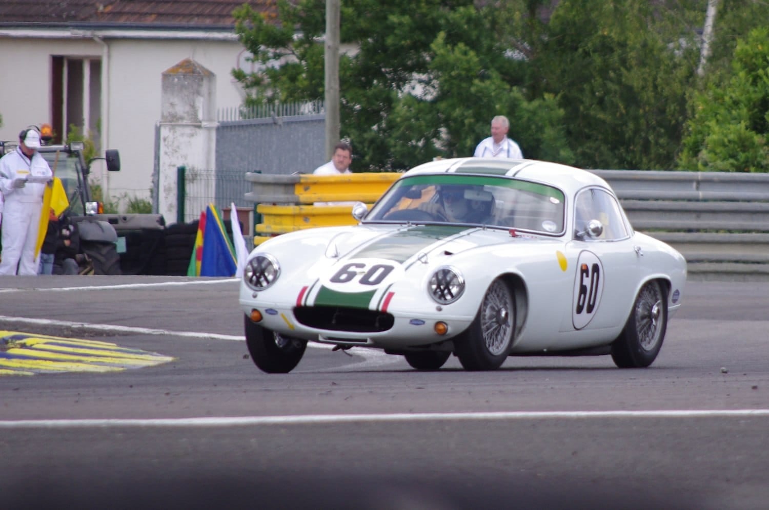 A white 1962 Lotus Elite with racing number 60 competing on a race circuit