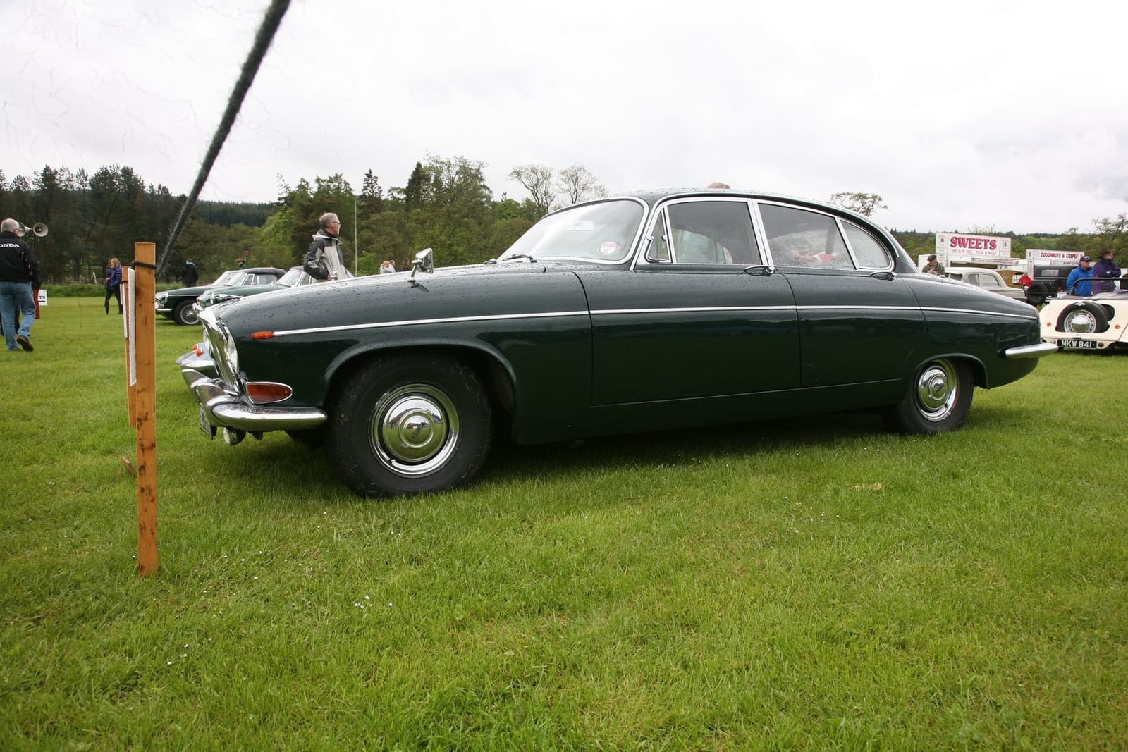 A dark green 1964 Jaguar Mk10 3.8 litre in side profile on grass