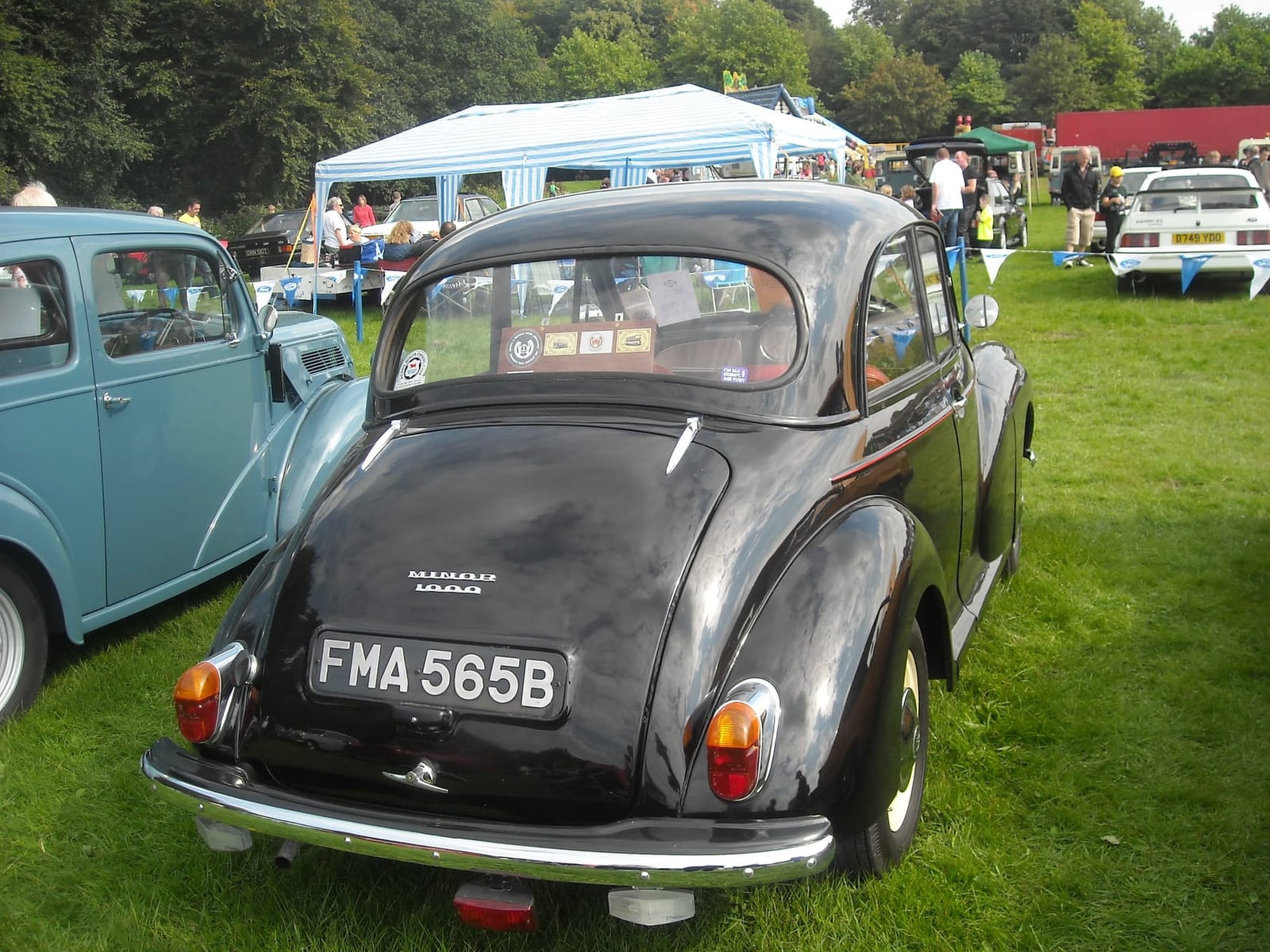 The rear three-quarter of a black 1964 Morris Minor 1000 at a showfield, UK registration FMA 565B