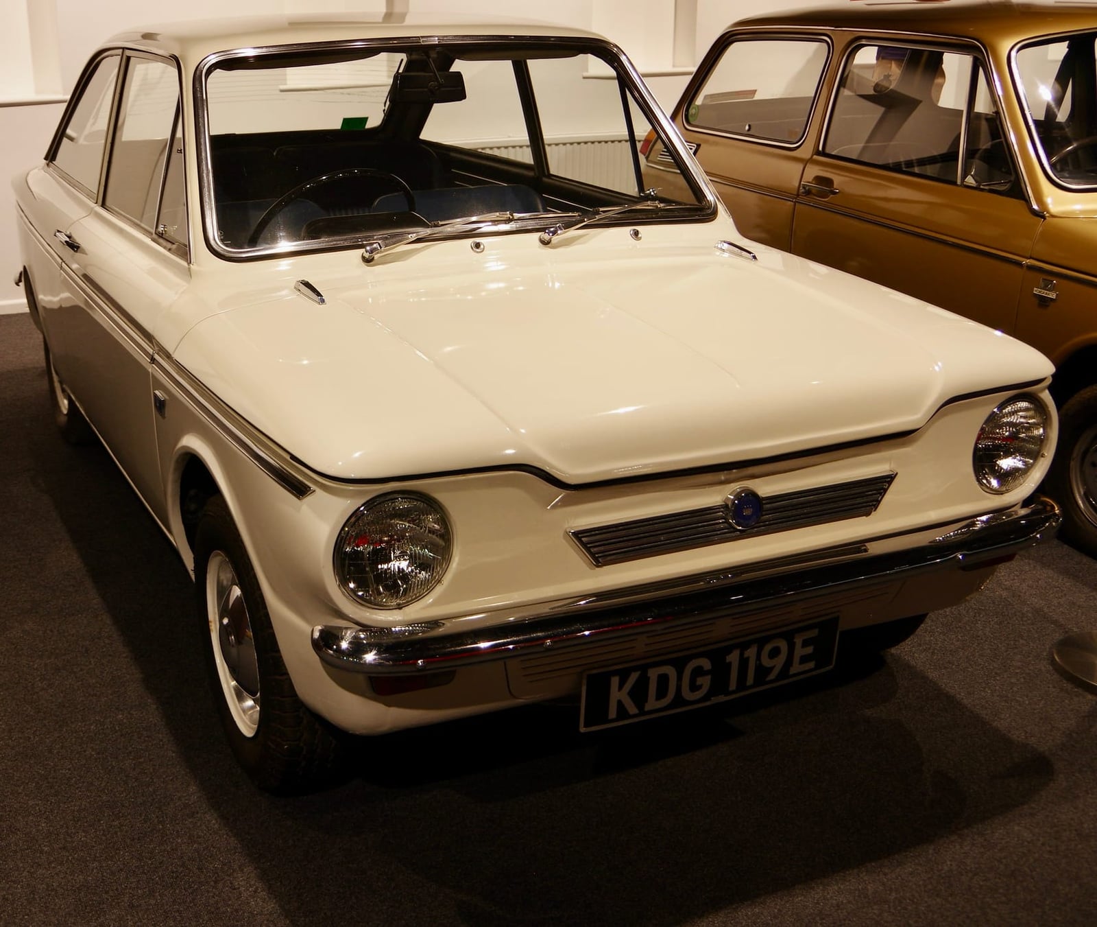 A white 1967 Hillman Imp Californian coupe displayed indoors